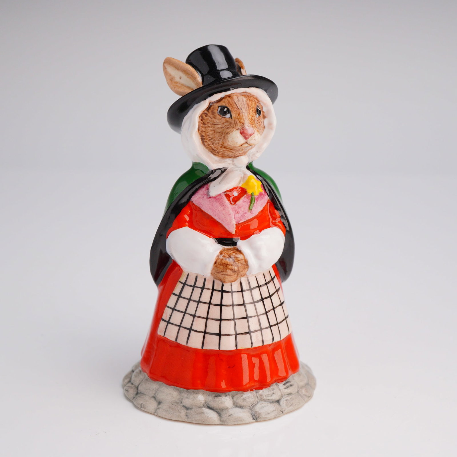 Royal Doulton Prototype Figurine Welsh Lady Bunnykins: A rare Welsh Lady Bunnykins prototype in traditional attire: tall black hat, white mob cap, black'trimmed green cloak, checked apron over a red bedgown, yellow daffodil on pink shawl collar. Base stam