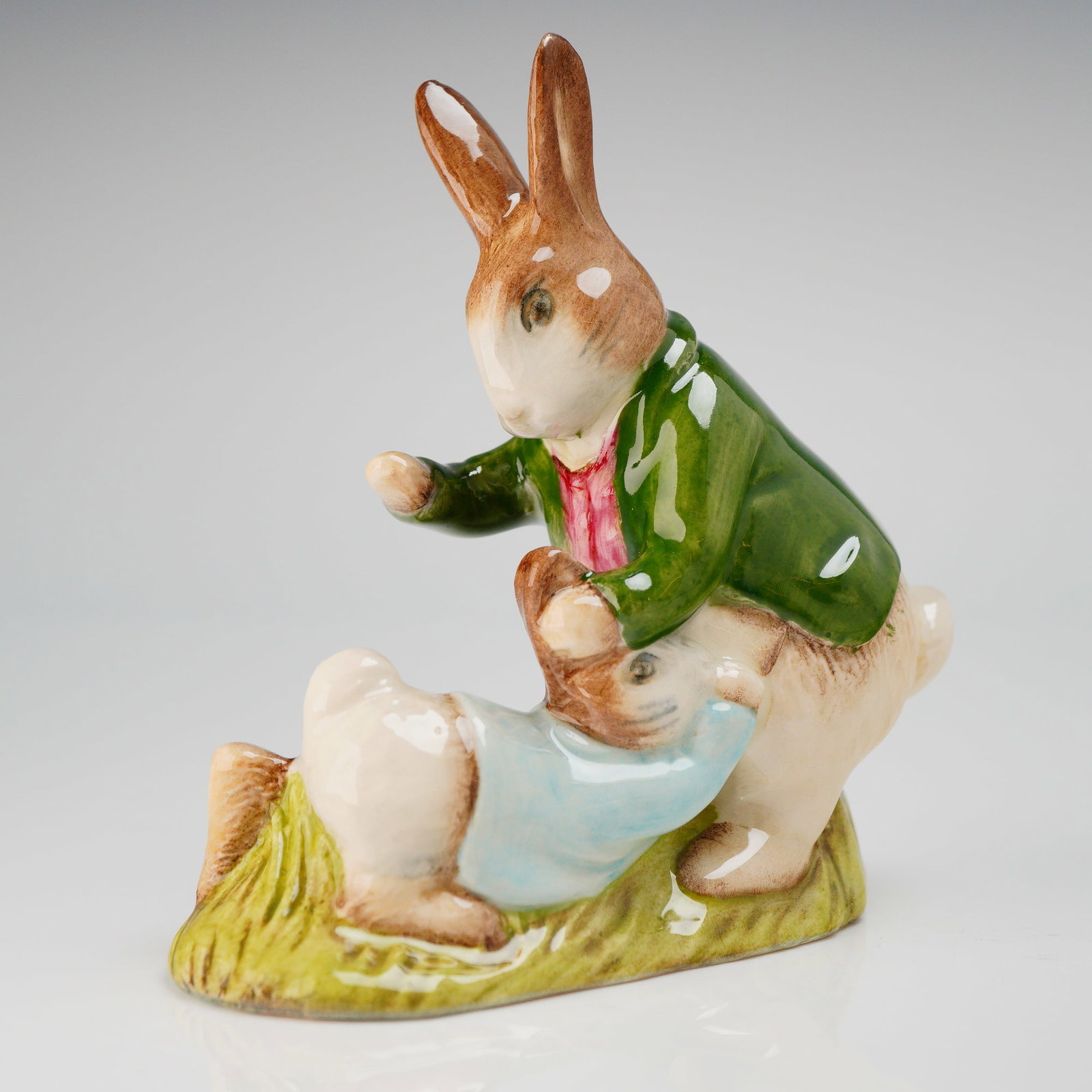 Royal Doulton Beatrix Potter Mr. Benjamin Bunny & Peter Rabbit Proto: This is a single glazed polychrome porcelain figurine produced by Royal Doulton, depicting two anthropomorphic rabbits from the Beatrix Potter series, identified through market consensus as Mr. Benjam