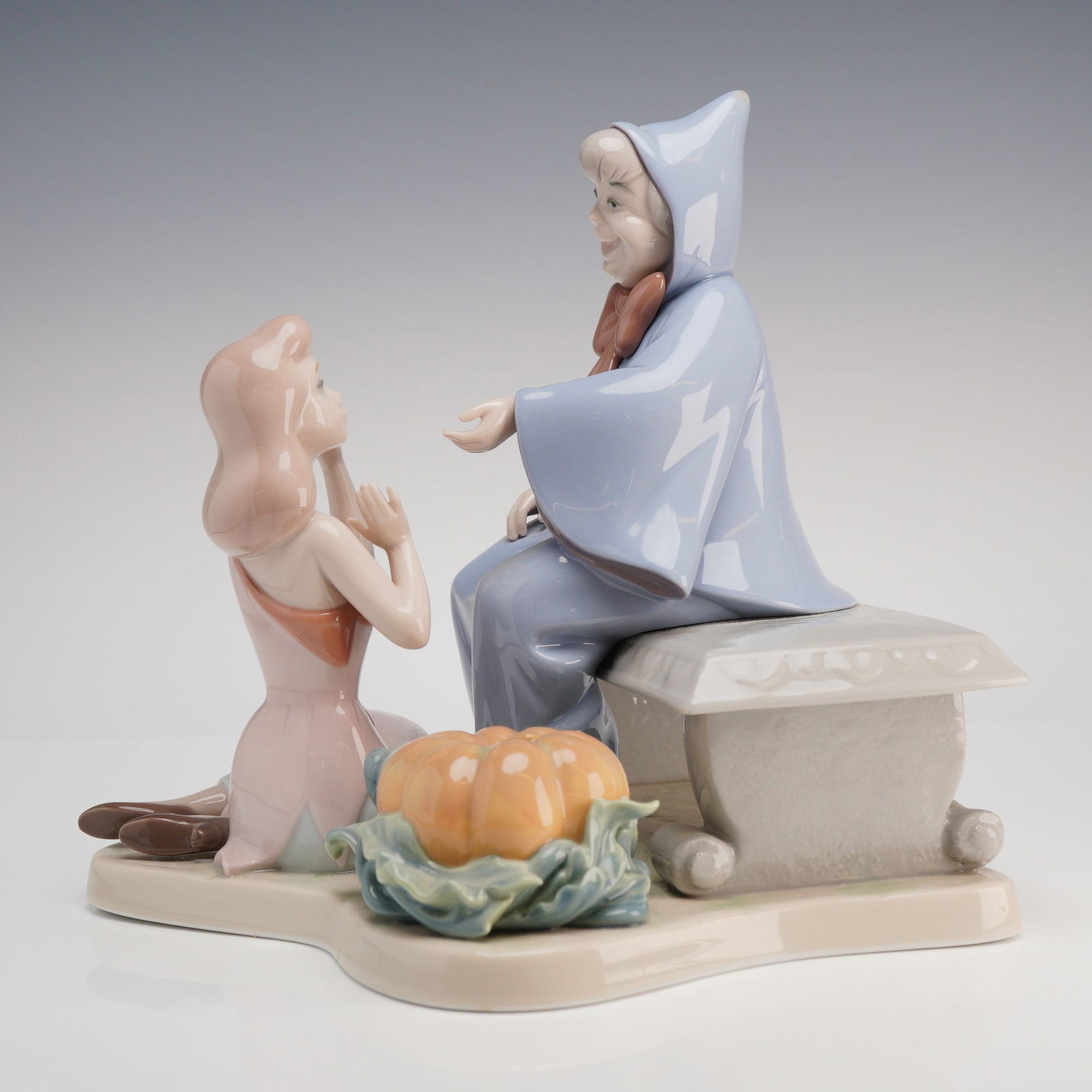 Lladro Cinderella and the Fairy Godmother Limited Edition Figurine: A Lladro glazed porcelain figurine titled Cinderella and the Fairy Godmother, model number 01007553. This piece was released as a limited edition for the 1994 Official Disneyana Convention and depicts