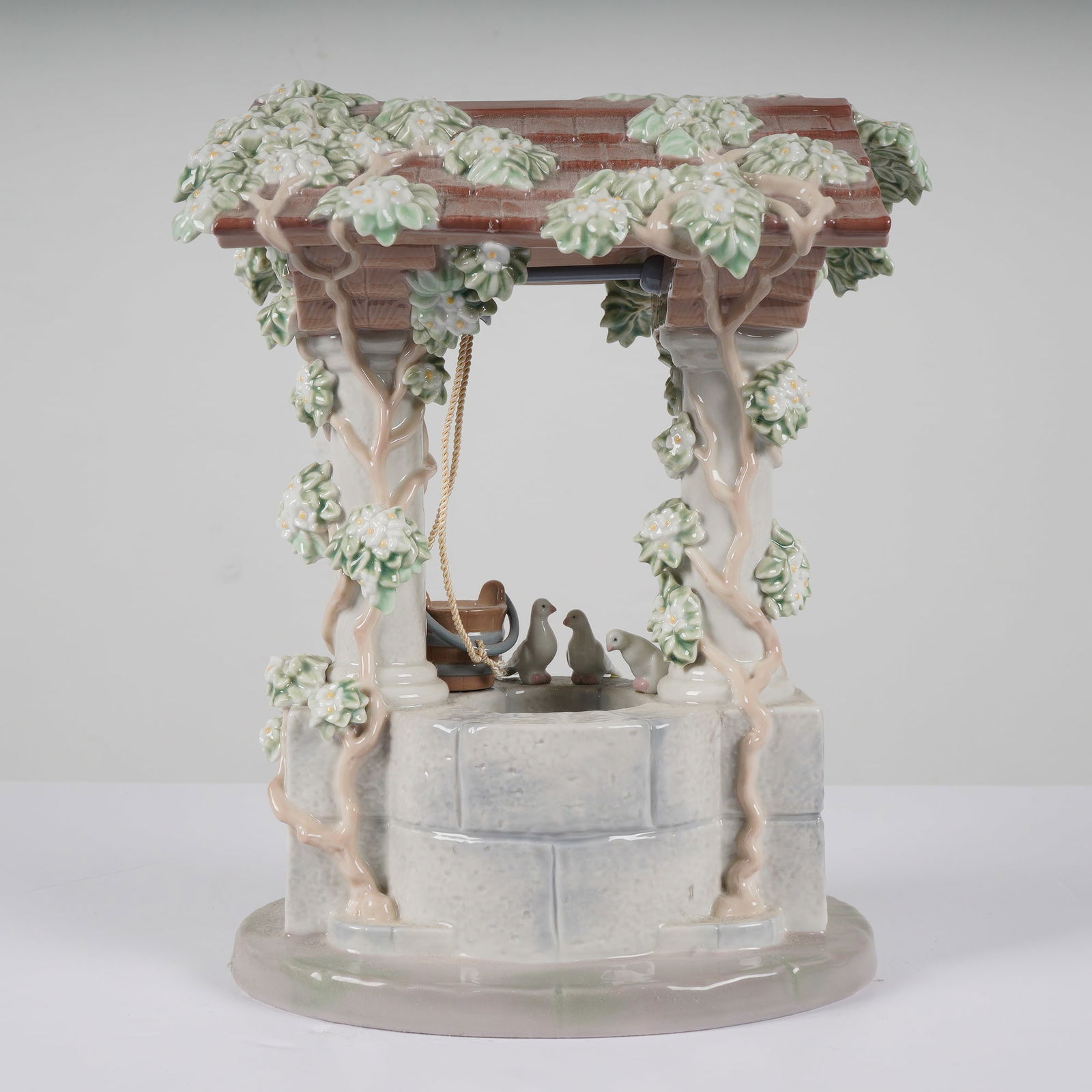 Lladro Snow White's Wishing Well Porcelain Figurine A Magical Evening: A Lladro glazed porcelain figurine titled Snow White's Wishing Well, reference number 7558, designed by Francisco Polope as part of the Disney Magical Evening collection. The structure depicts a stone