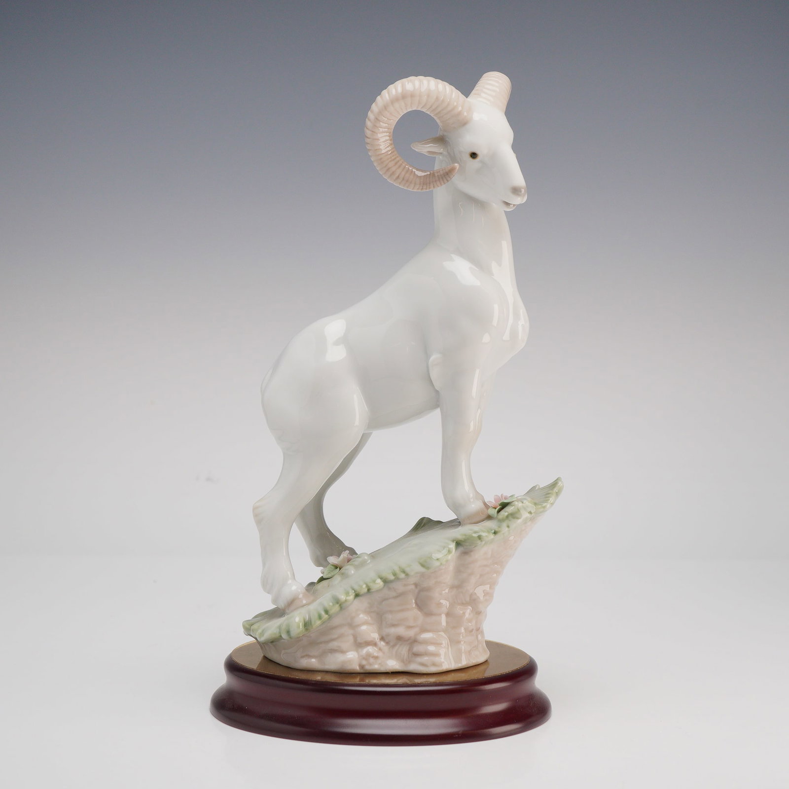 Lladro Porcelain Chinese Zodiac Figurine The Goat 1006922: This glazed porcelain figurine by Lladro is part of the manufacturer's Chinese Zodiac Collection. The piece depicts a majestic ram standing on a rocky outcrop accented with green grass and delicate