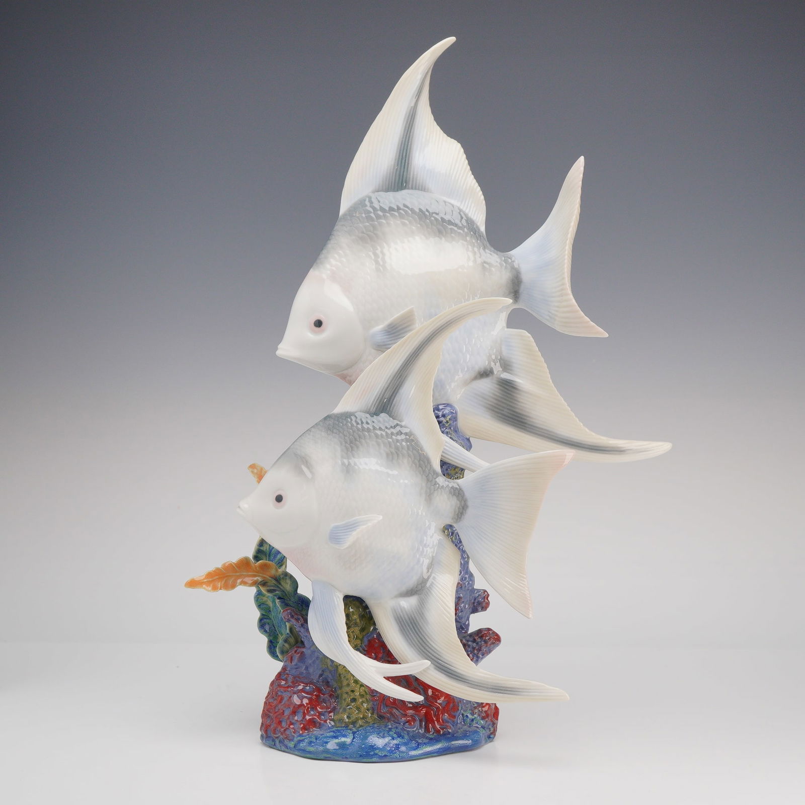 Lladro Underwater Explorers: A Lladro glazed porcelain figurine titled "Underwater Explorers" (model 6742), depicting two angelfish swimming gracefully around a vibrant coral reef base. The fish are rendered in a soft,