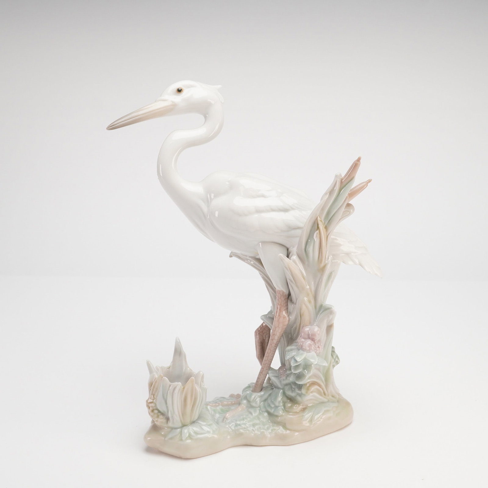 Lladro Heron's Realm Glossy Porcelain Candle Holder Model 6882: A Lladro glossy porcelain candle holder titled Heron's Realm, model number 6882. Sculpted by Salvador Debon and first issued in 2002, this piece depicts a majestic white heron or egret standing in a