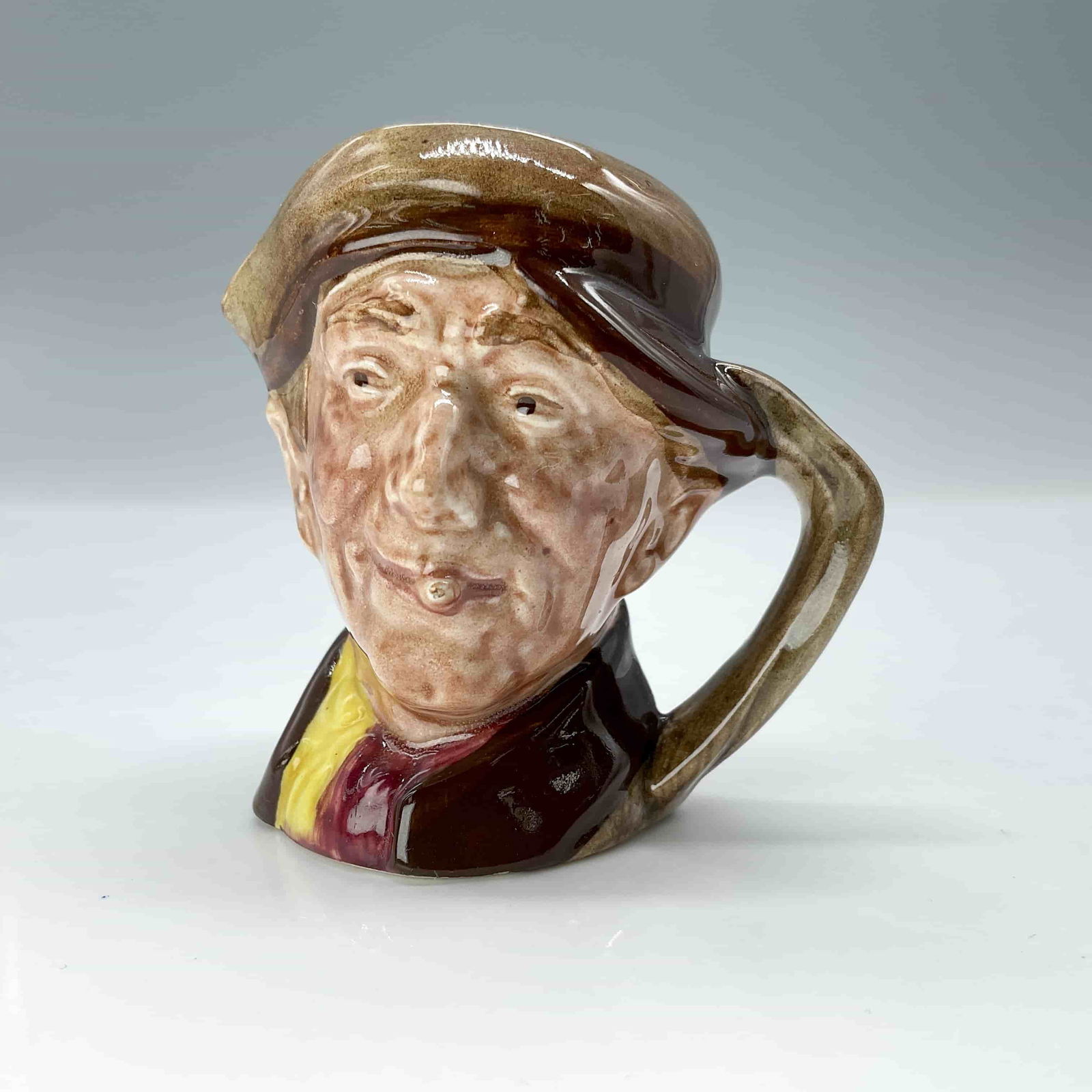 Arry D6249 - Mini - Royal Doulton Character Jug: This mini toby jug has brown hat and coat, red and yellow scarf. Royal Doulton backstamp. ArtistHarry Fenton Dimensions2.25" L x 2" W x 2.25" H Date or Era1947-1960 Manufacturer or BrandRoyal Doulton