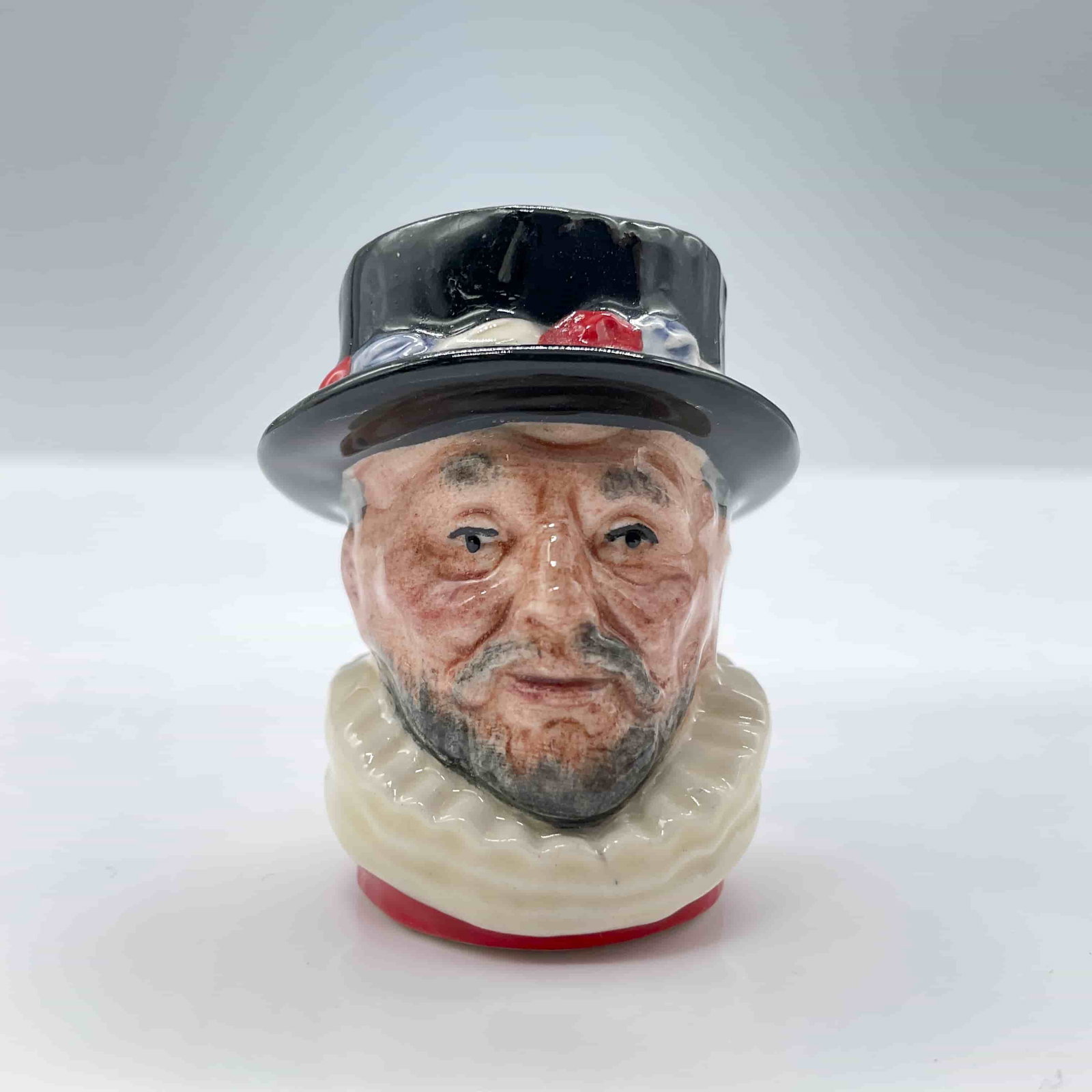 Beefeater D6806 - Tiny - Royal Doulton Character Jug: Variation Four, scarlet with black hat; white ruff; scarlet tunic. Royal Doulton backstamp. ArtistRobert Tabbenor Dimensions1.5"L x 1.25"W x 1.5"H Date or Era1988 - 1988 Manufacturer or BrandRoyal Dou
