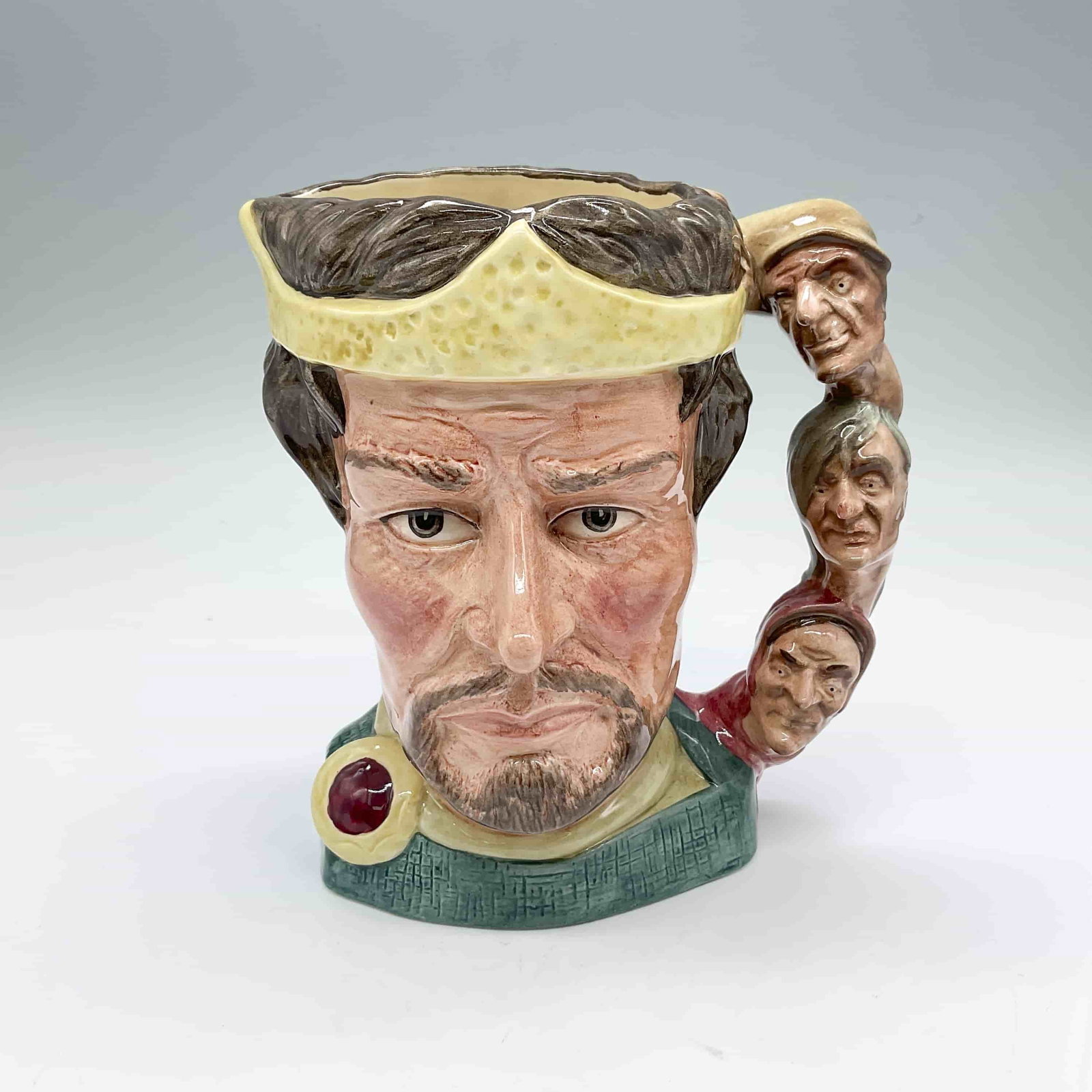 Macbeth D6667 - Large - Royal Doulton Character Jug: Part of the Shakespearean Collection. Style Two; hand made and hand painted. The handle is three witches facing forward. Royal Doulton backstamp. ArtistMichael Abberley Dimensions6.25"L x 5.25"W x 6.7