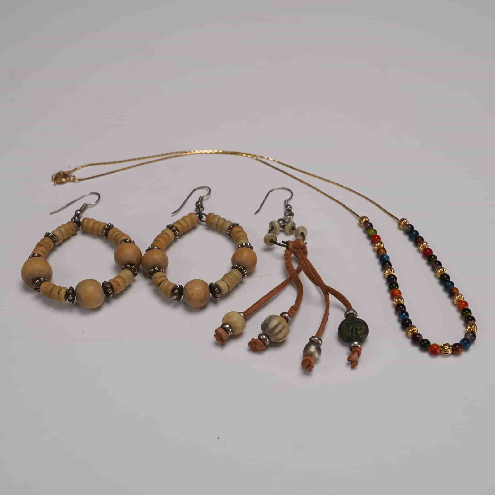 4pc Group of Beaded Costume Jewelry: Assorted group of four vintage-style beaded jewelry pieces, including a pair of hoop earrings strung with natural wood and metallic beads, a single dangle earring composed of ceramic rings and