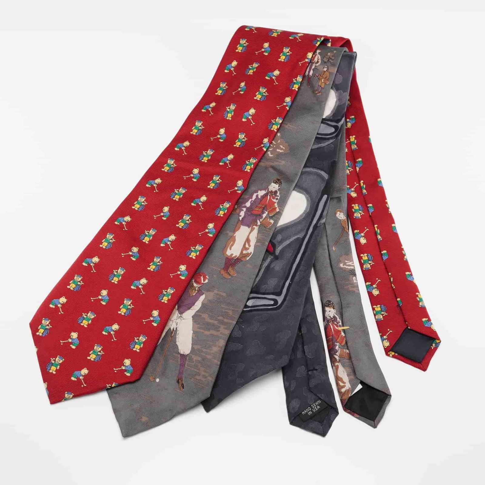 3pc Golf Theme Necktie Set, Daskal, Resmann, Resilio: A trio of golf themed neckties including a grey Laurence Branescu for Robert Daskal tie featuring a classic golfing scene, a red Resmann tie patterned with whimsical golfing teddy bears (also marked