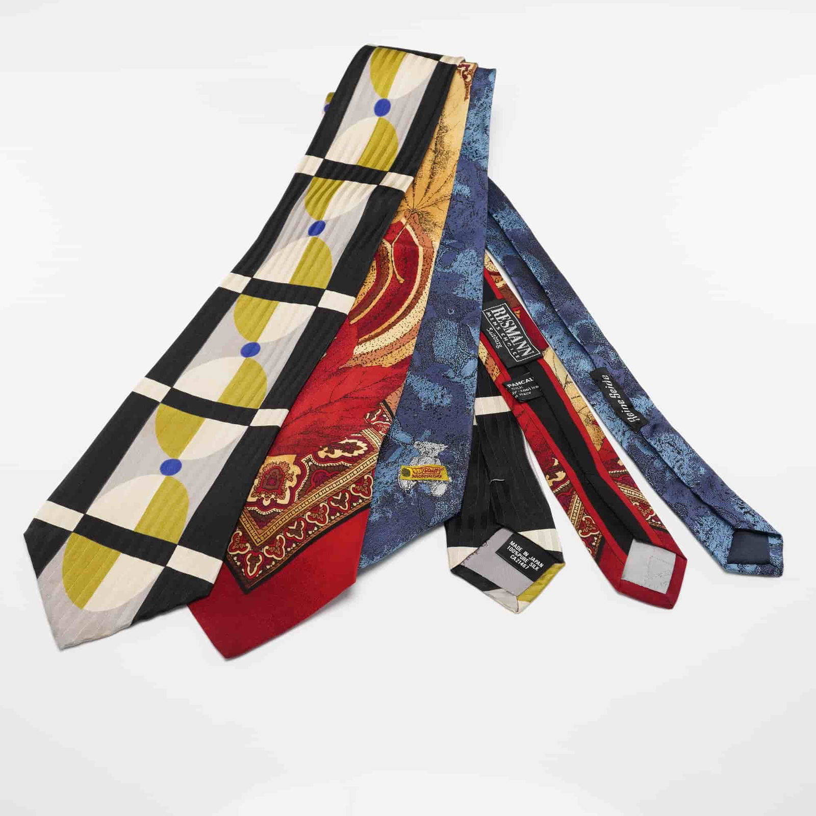 3pc Steiff Club, Resmann, and Modules Neck Ties: A group of three men's ties that includes a Modiles Classics tie with a bold geometric grid pattern in black, cream, olive, and blue, a Vitaliano tie with a red ground and an ornate paisley and leaf