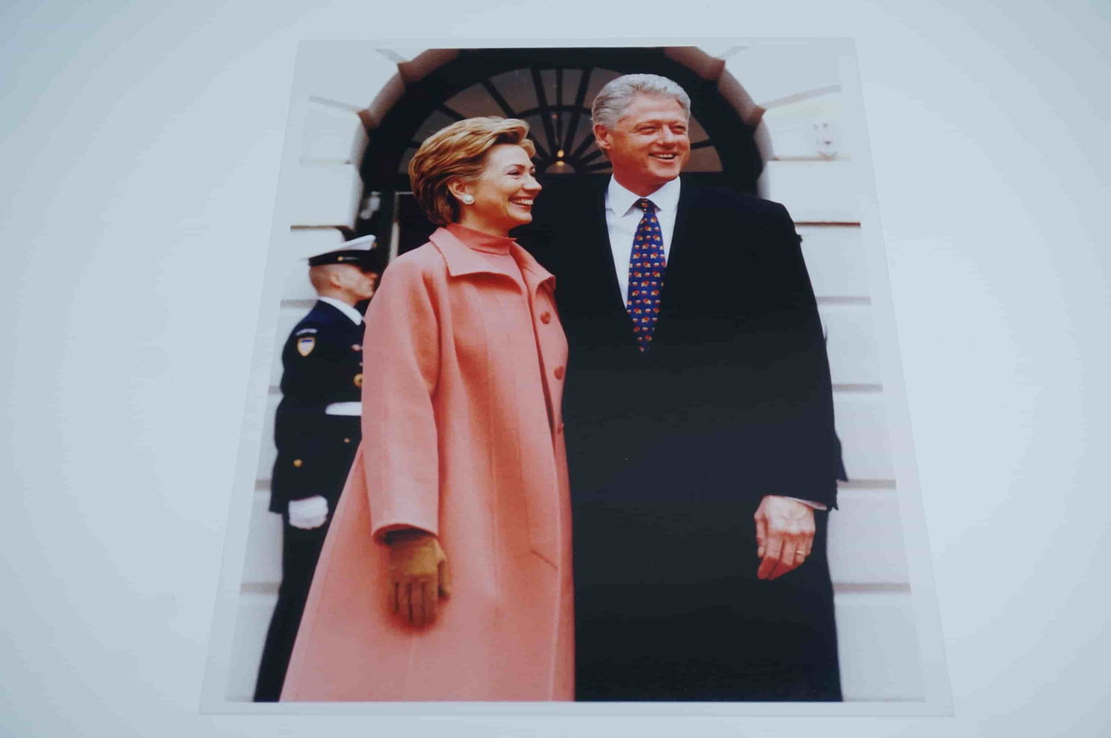 Presidential Photograph of Bill and Hillary Clinton: A high-quality printed photograph capturing former U.S. President Bill Clinton and former First Lady Hillary Clinton in an official setting. The image shows them standing together outside a formal gov