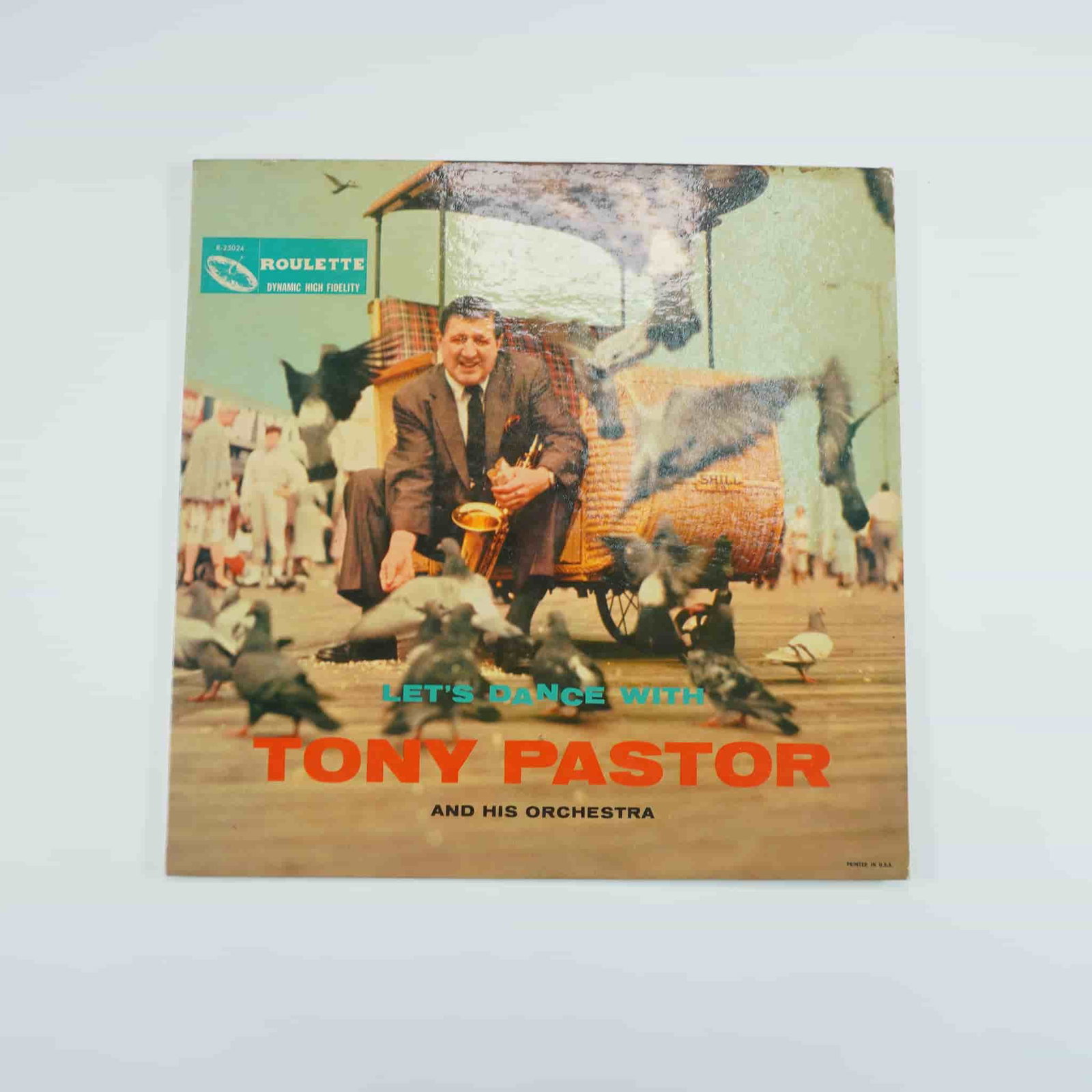 Tony Pastor and His Orchestra Let's Dance With Vinyl LP: Tony Pastor and His Orchestra's Let's Dance With is a lively big band and swing album released under the Roulette Records label. Featuring the charismatic vocals and saxophone skills of Tony Pastor, t