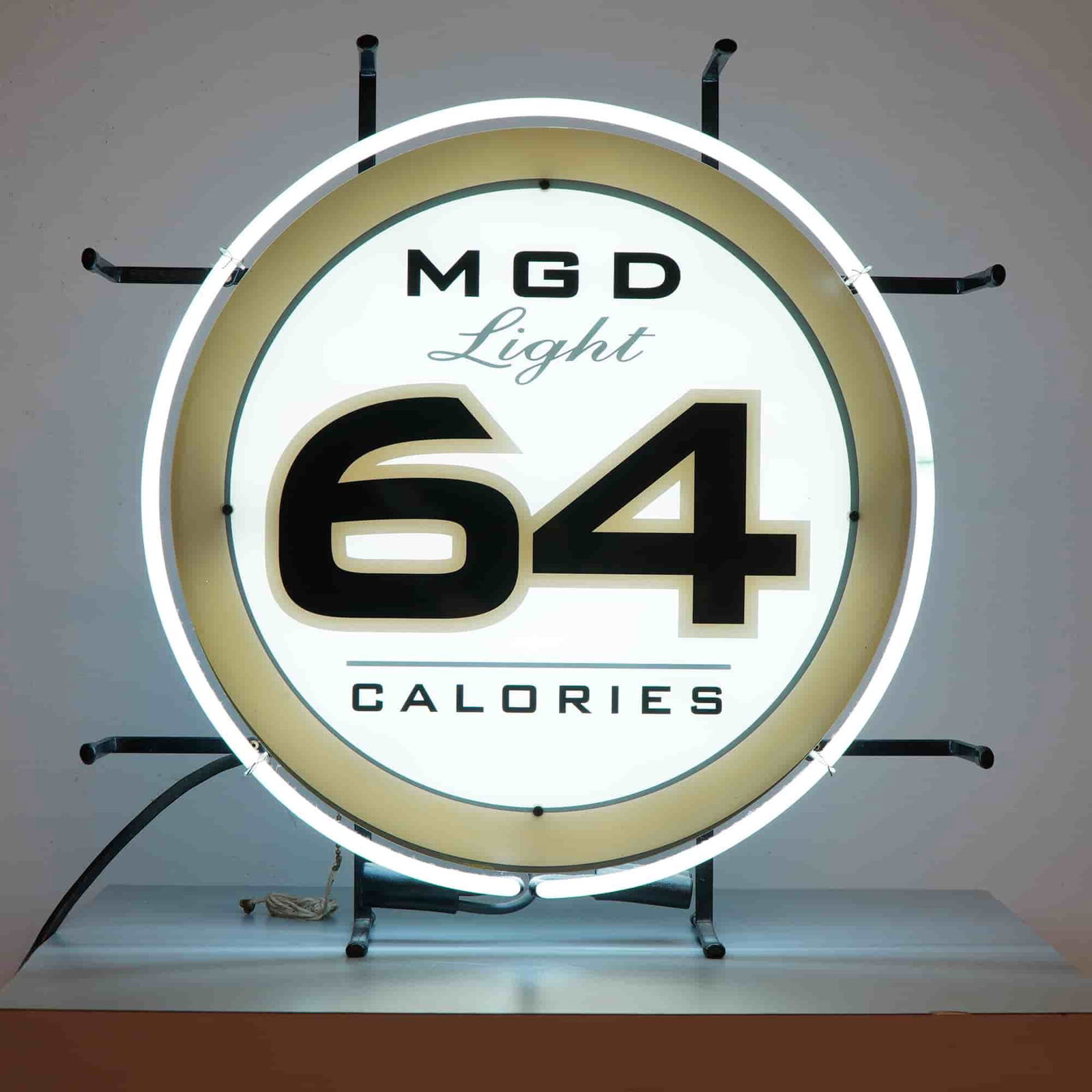 Original Miller MGD Light 64 Calories Neon Sign: A vibrant piece of breweriana, this Miller Genuine Draft Light 64 Calories neon sign is a true collector's gem. Featuring bold black lettering with the number 64 illuminated against a bright white