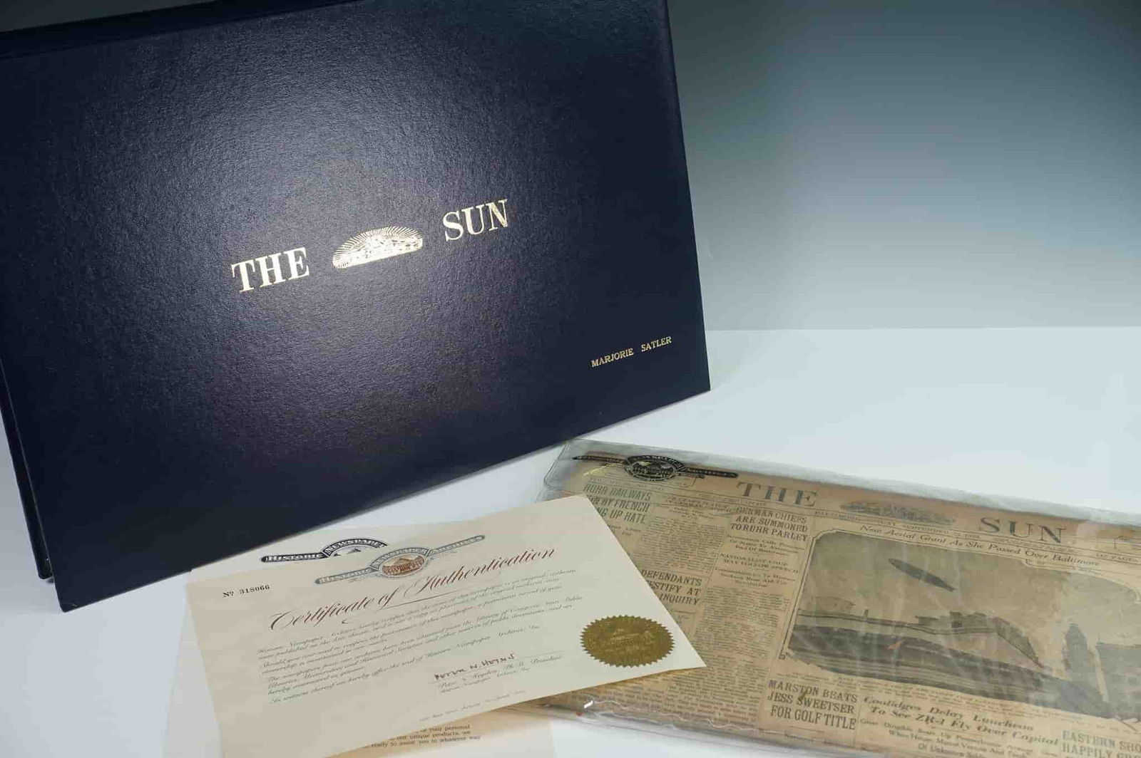The Baltimore Sun Newspaper Original 1920s Edition In Archival Portfolio: A historic American newspaper presented in a personal leatherette archival portfolio marked with the name Marjorie Satler. This preserved newspaper dates to the early 1920s, with visible headlines