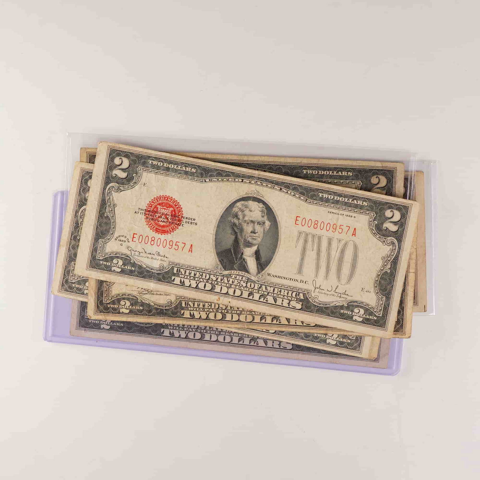 7pc 1928 U.S. Two Dollar Red Seal Notes, Series D,F,G: A group of seven 1928 series United States $2 Red Seal Notes, including two Series D, one Series F, and four Series G issues. Each note features a portrait of Thomas Jefferson at center on the