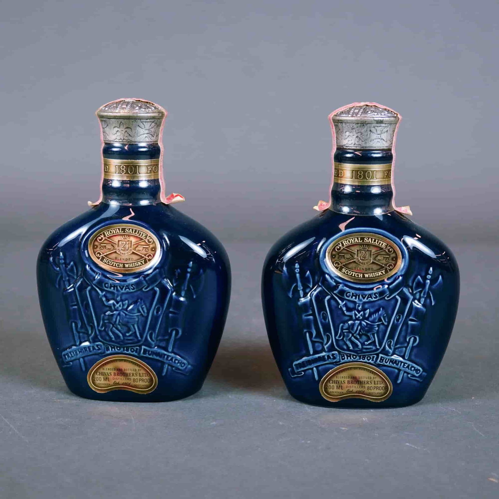 Pair of Chivas Brothers Royal Salute 21 Years Old Blended Scotch Whisky Decanters: This lot features a pair of Royal Salute 21 years old blended Scotch whisky miniature decanters produced by Chivas Brothers Ltd. of Aberdeen, Scotland. These flagons are crafted from deep sapphire