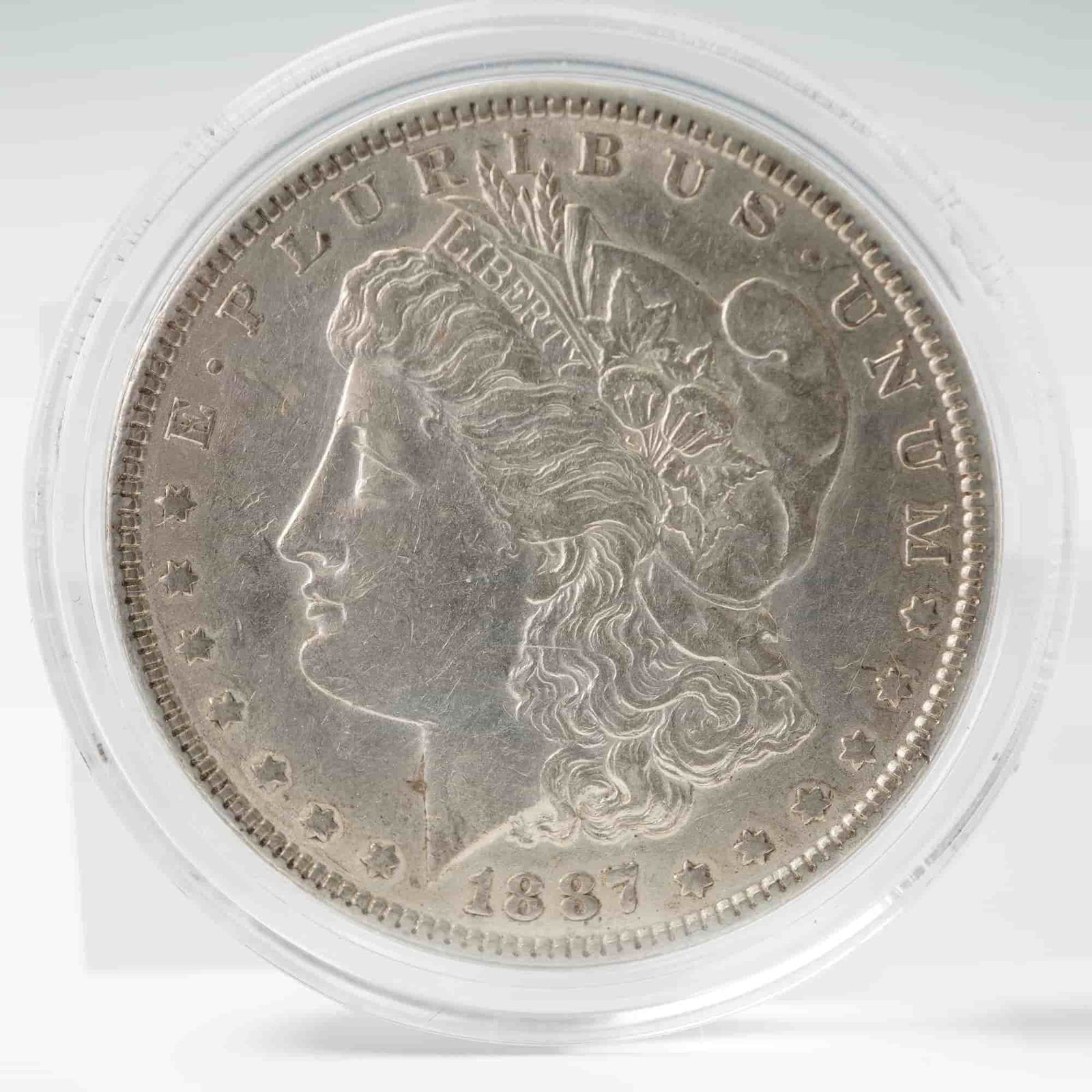 1887 Morgan Silver Dollar: With an obverse features a left-facing profile of Lady Liberty wearing a Phrygian cap adorned with wheat and cotton, symbolizing liberty and unity. The inscriptions include E PLURIBUS UNUM and the dat