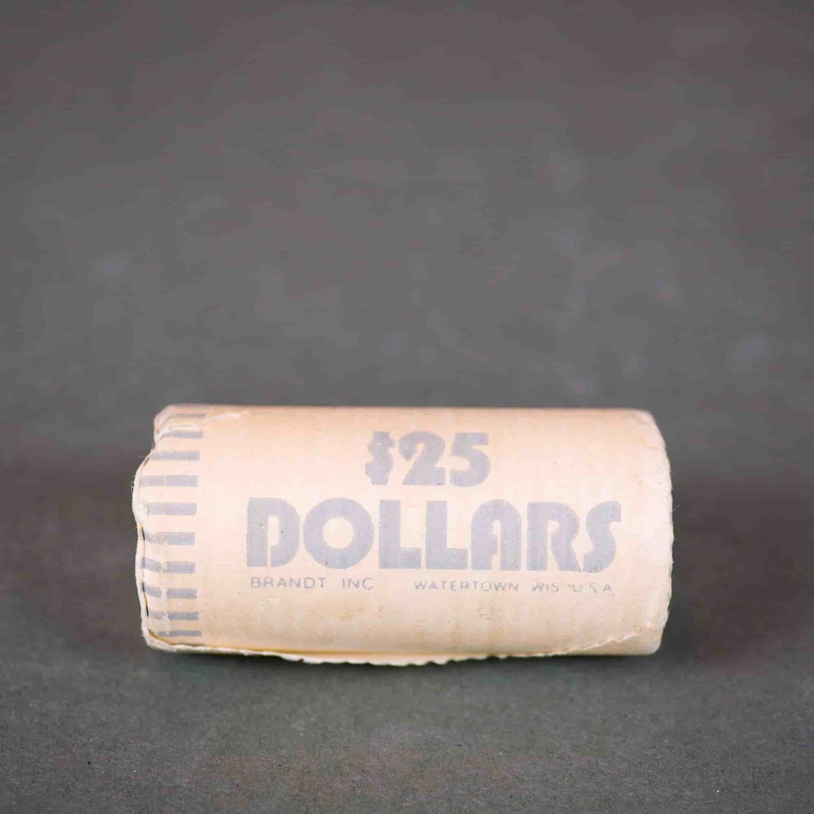 US $25 Susan B. Anthony Dollars, 1979-1999, Uncirculated: Original bank-wrapped roll of US Susan B. Anthony dollars. Face value: $25.00. Materials: Coins. Series: Susan B. Anthony Dollar. Date: 1979-1999. Manufacturer: Brandt Inc., Watertown, WIS. The roll