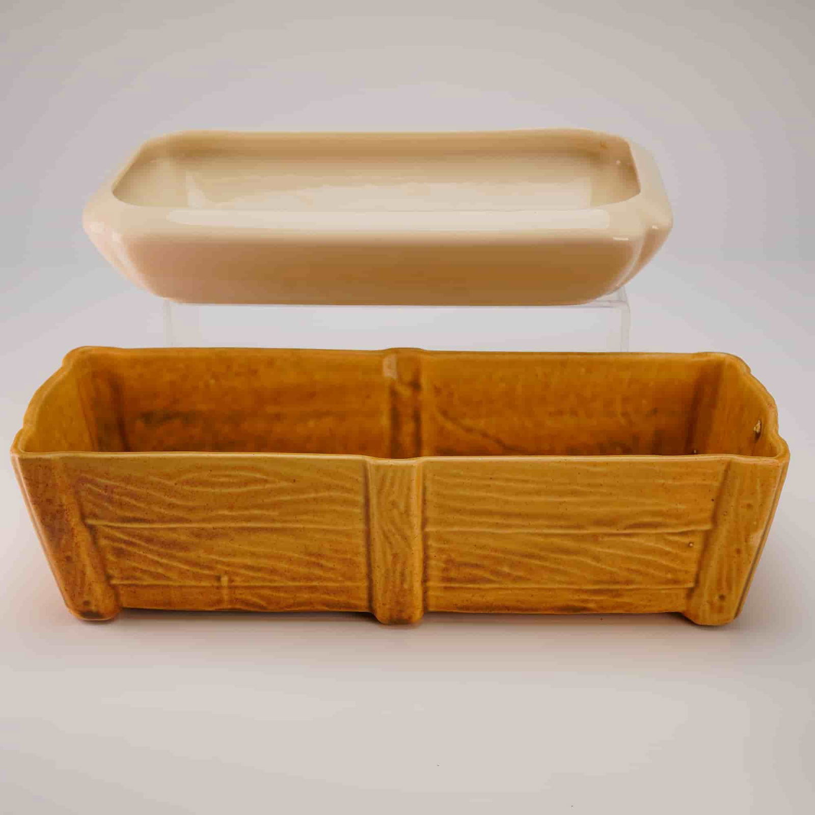 A Pair of Mid-Century Ceramic Planters by Brush McCoy and Hyalin: This lot consists of a pair of two ceramic pottery vessels. The first item is a rectangular, divided trough planter, modeled in a novelty rustic style to resemble a wooden crate or plank fence. It is