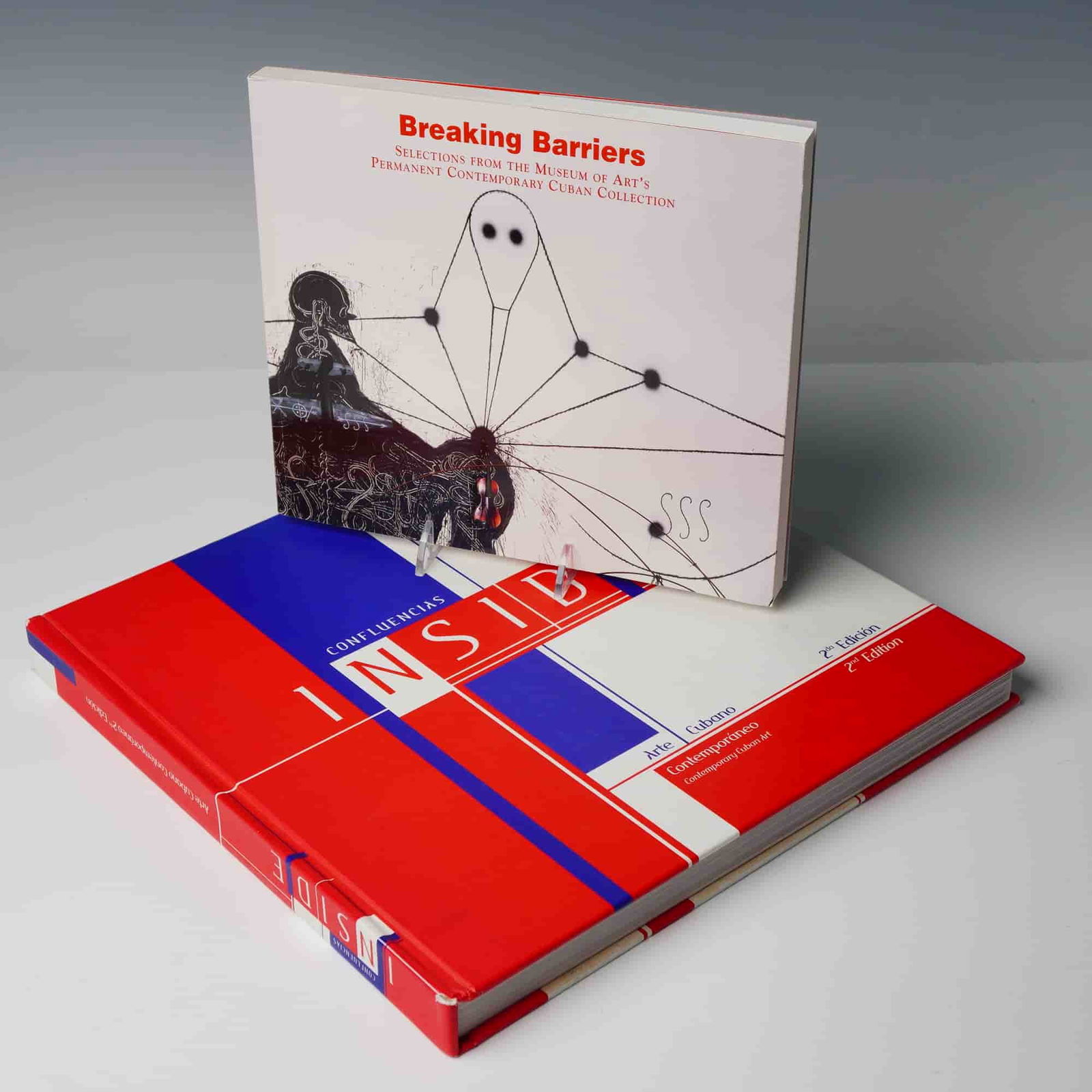 Two Vols: Breaking Barriers & Confluencias Cuban Art Books: A pair of exhibition catalogues focusing on Contemporary Cuban Art, published in square quarto format, comprising two distinct volumes. VOLUME I: Breaking Barriers. Selections from the Museum of Arts