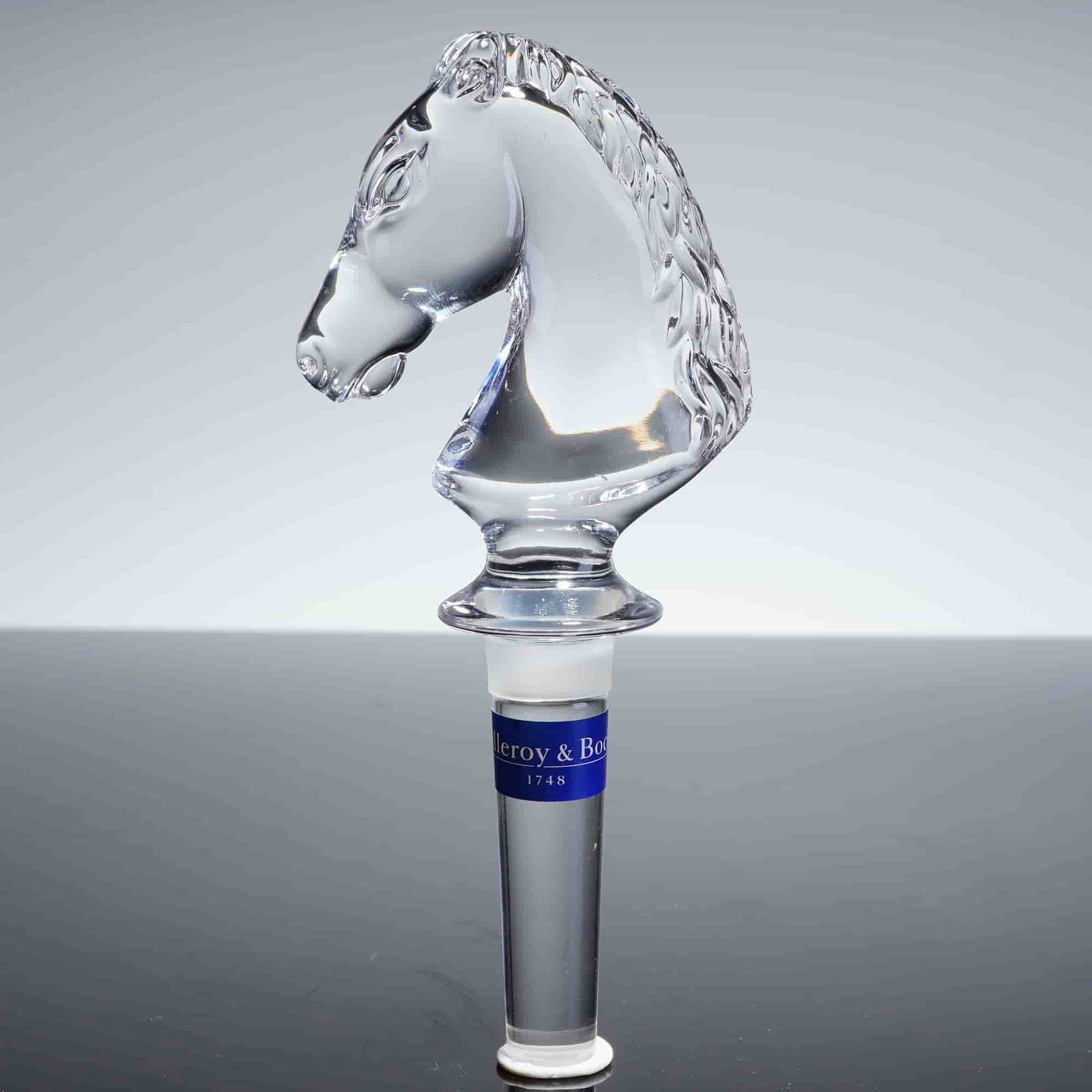 Villeroy & Boch Crystal Horse Head Bottle Stopper: The stopper is constructed from clear, highly polished crystal, intricately molded and faceted in the shape of a horse head. The clear cylindrical shank is fitted with white rubber intended for sealin