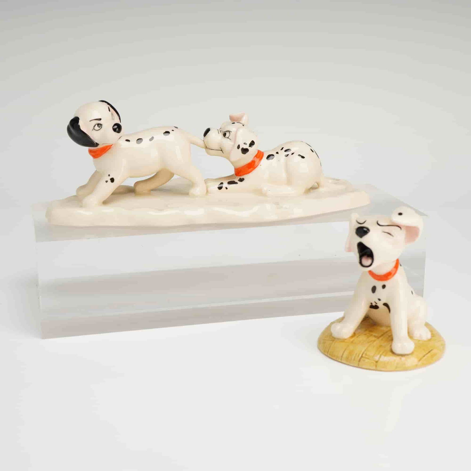 A Pair of Royal Doulton Disney 101 Dalmatians Figurines: Two Royal Doulton ceramic figurines from Disney's 101 Dalmatians series, including Penny (DM2) and Lucky and Freckles on Ice (DM10). Dimensions7.00"L x 3.25"W x 2.50"H Weight11.00oz
