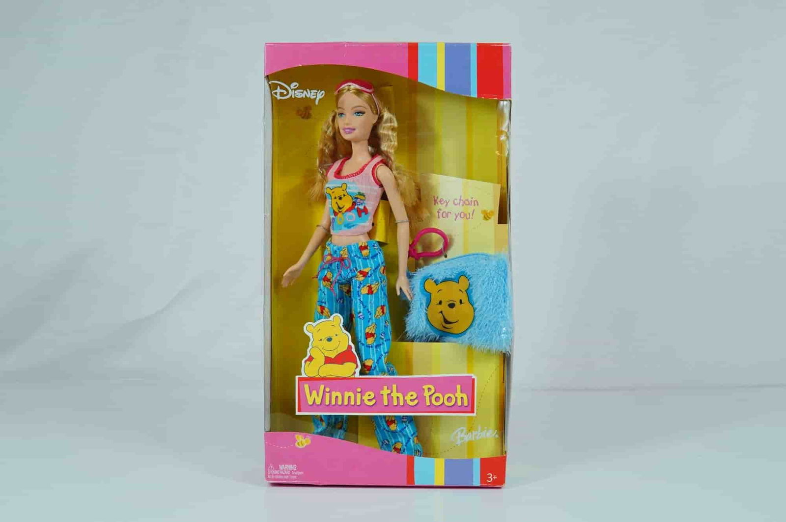 Mattel Disney Winnie the Pooh Barbie Doll, 11.5 Inches: Manufactured by Mattel, Inc., this 2004 Disney Winnie the Pooh Barbie doll is constructed of vinyl with rooted synthetic blonde hair styled in wavy pigtails. The doll features painted blue fixed eyes