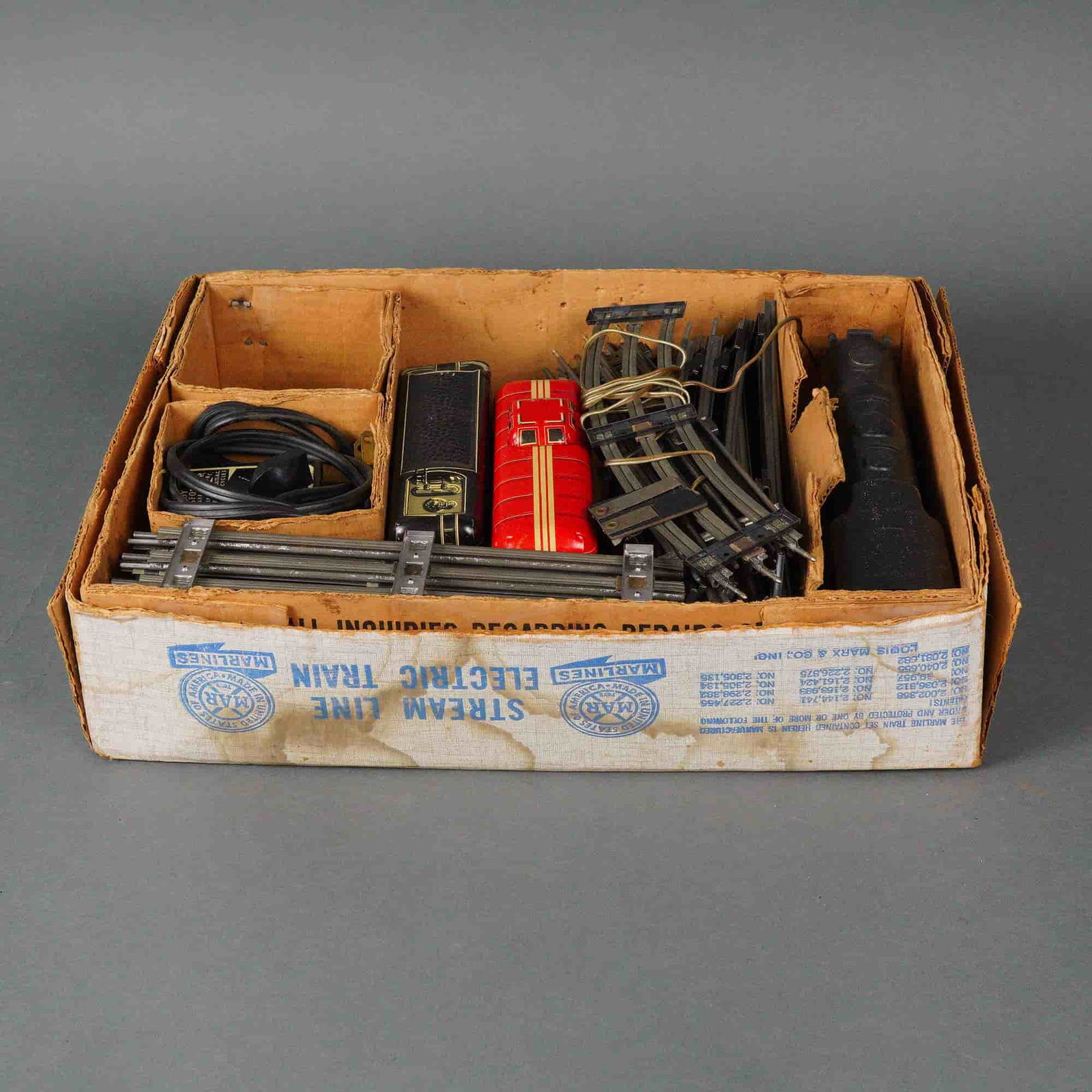 Collection of Marx Line Stream Line Electric Train Set Components: A vintage electric tinplate toy train set manufactured by Marx Line, identified on the original packaging as a "Stream Line Electric Train." The collection consists of 13 primary components. Rolling