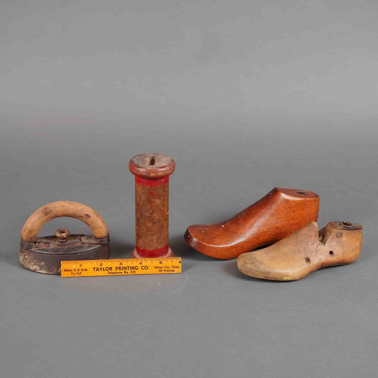 5pc Cobbler Implements including Wood Forms, Spool, & More: Primarily constructed from wood and cast iron. The collection includes two child's wooden shoe forms. One form is constructed of polished reddish-brown hardwood, exhibiting a smooth surface. The secon