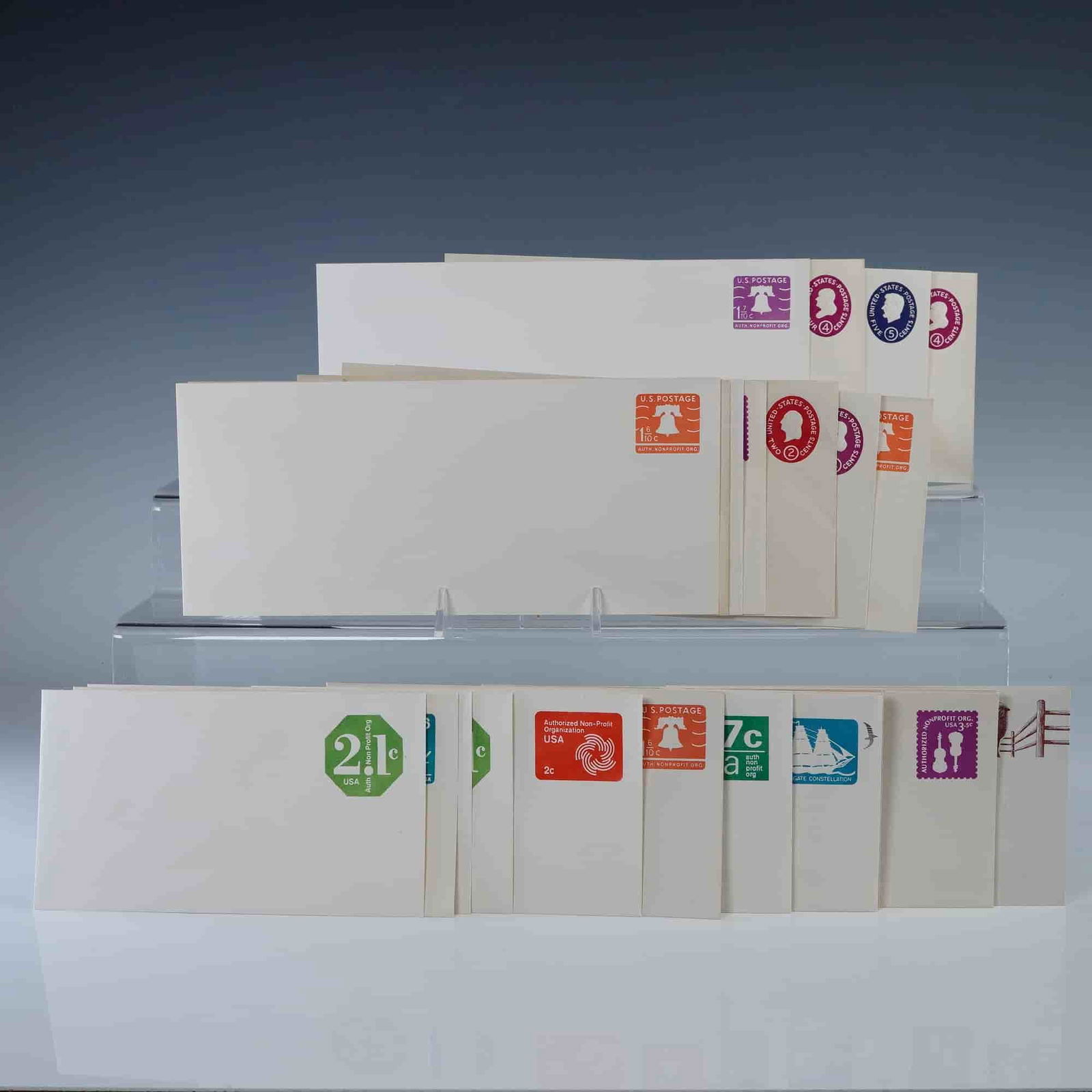 27pc Vintage US Postal Stationery Envelopes: Collection of thirty vintage United States postal stationery envelopes with pre-printed postage in assorted denominations and designs. Includes colorful examples featuring motifs such as the Liberty