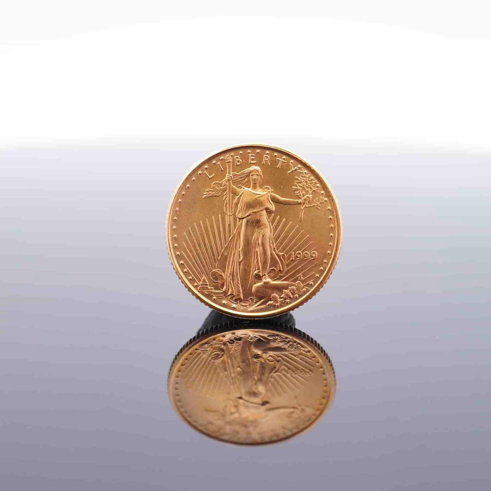 1999 1/10 Fine Gold $5 American Gold Eagle Coin: Minted by the Philadelphia Mint. The obverse side depicts an effigy of Liberty with the date to the right. The reverse side depicts an eagle in flight above a nest of birds with the country name at th
