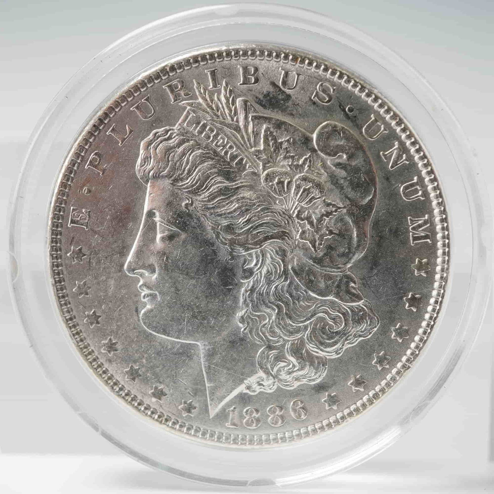 1886 Morgan Silver Dollar: With an obverse features a profile portrait of Lady Liberty wearing a Phrygian cap adorned with wheat and cotton, symbolizing agricultural prosperity. The reverse displays an eagle with outstretched w