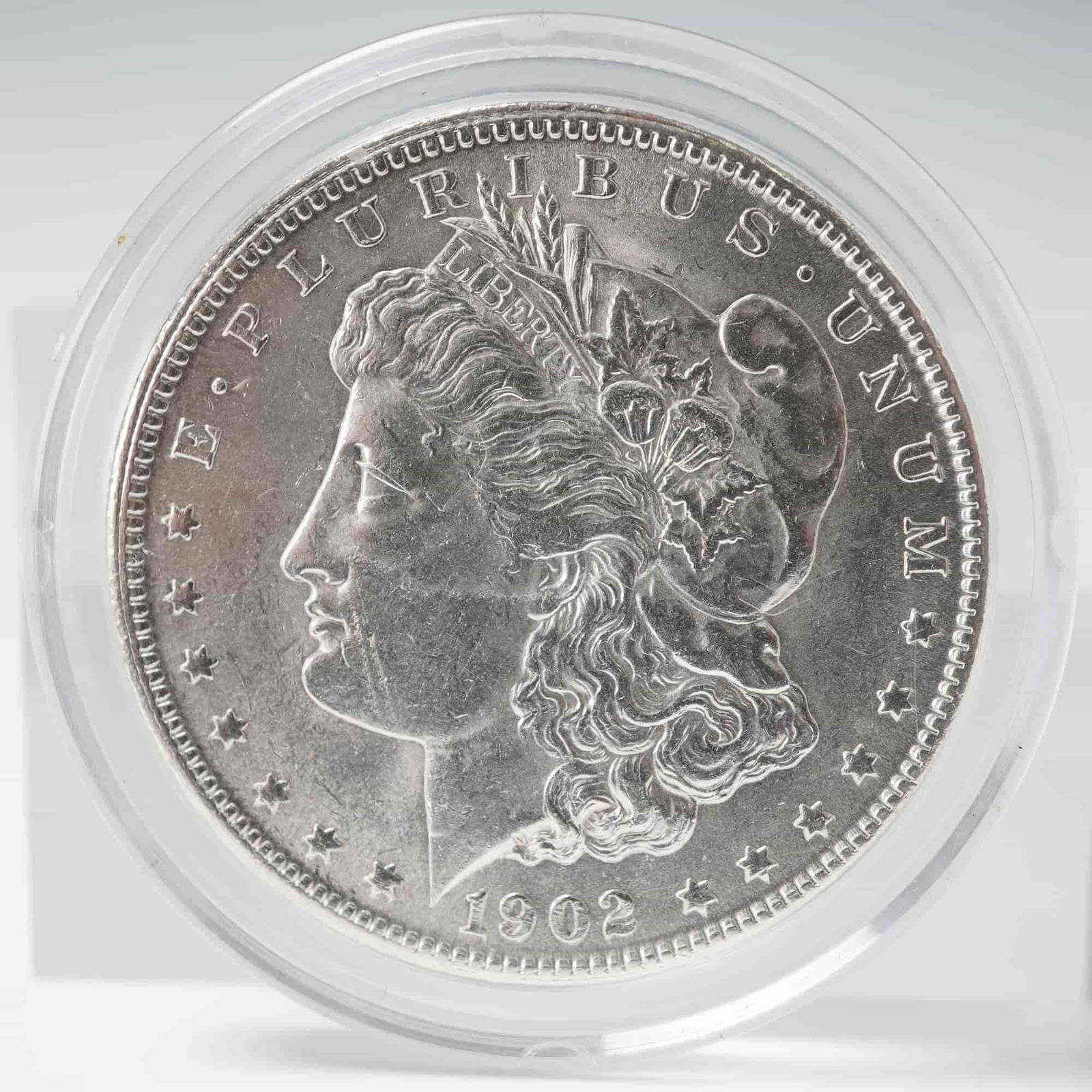 1902-O Morgan Silver Dollar: Struck at the New Orleans Mint, this classic U.S. silver dollar features the profile of Liberty on the obverse, wearing a Phrygian cap adorned with wheat and cotton, with the inscriptions E PLURIBUS U