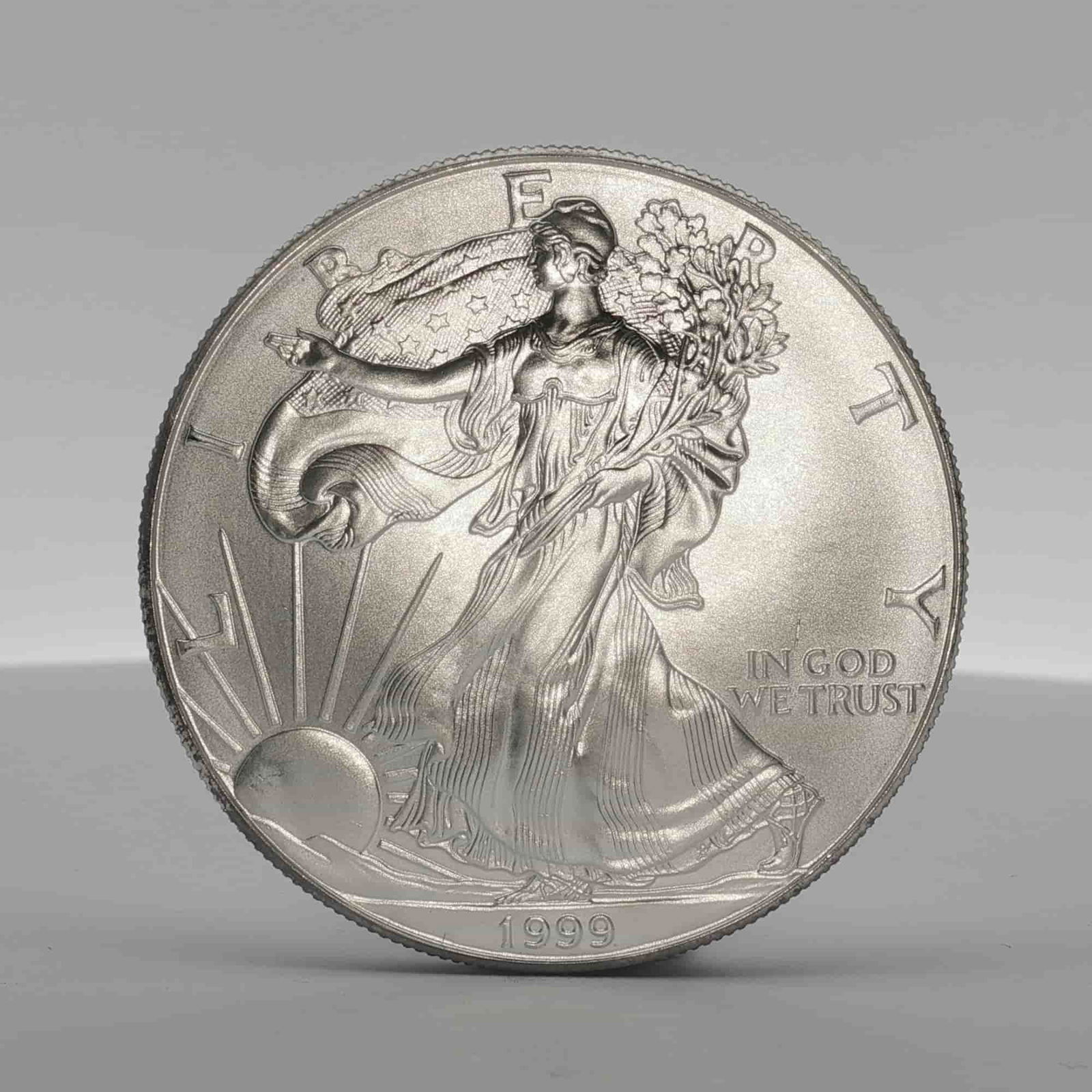 1999 American Silver Eagle One Dollar Coin: Minted by the Philadelphia Mint. The obverse side depicts an effigy of Walking Liberty with the date below. The reverse side depicts an heraldic eagle with shield and lettering United States of