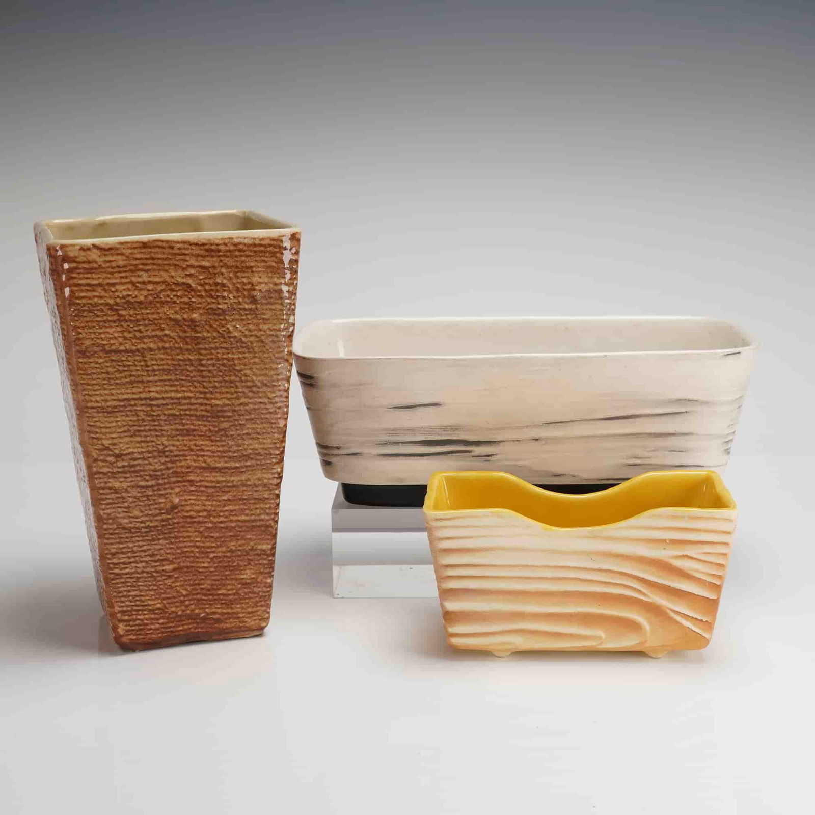 A Trio of Mid-Century Modern Shawnee Pottery Planters and Vase: A collection of three (3) vintage Mid-Century Modern ceramic planters manufactured by Shawnee Pottery, U.S.A. This 3pc set includes a tall, tapered planter, consistent with the style of a burlap