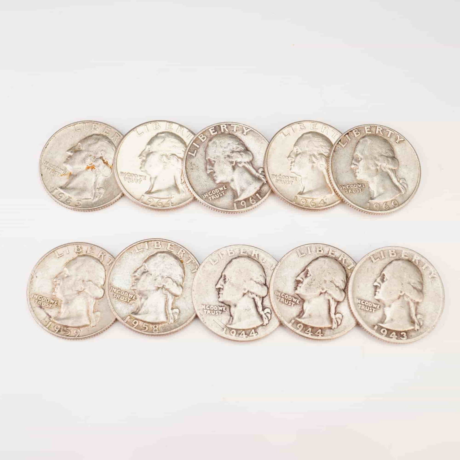 1943,1944,1958,1959,1960,1963,1964 Ten Washington Silver Quarter Circulated Coins: Minted by Philadelphia Mint. The obverse depicts a portrait of George Washington facing left, accompanied by the motto: "IN GOD WE TRUST" and surrounded with the lettering: "LIBERTY". The reverse