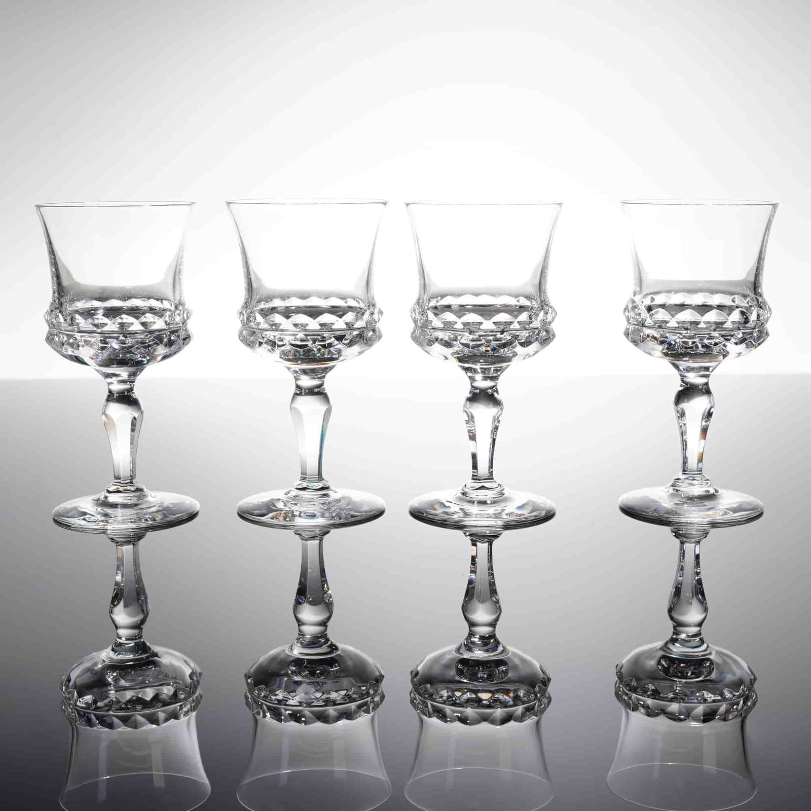 Collection of Four Orrefors Silvia Crystal Sherry Glasses: A collection of four lead crystal stemmed glasses in the 'Silvia' patern by Orrefors, Sweden. These items are identiied as Sherry glasses. Each glass features a tapering bowl that iares slightly at th
