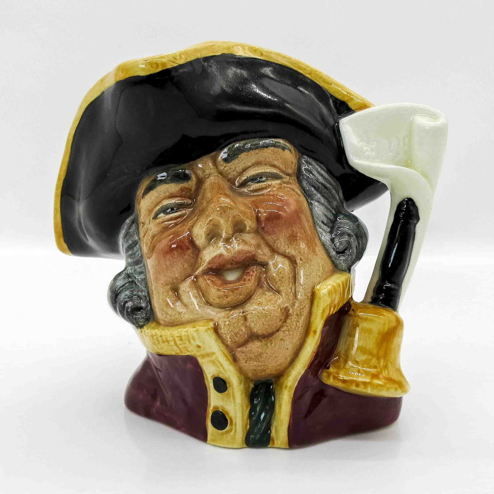 Town Crier D6537 - Small - Royal Doulton Character Jug: Style One, bell on scroll handle. Black hat trimmed with gold; scarlet coat trimmed with gold. Royal Doulton backstamp. ArtistDavid B. Biggs Dimensions3.25"H Date or Era1960 - 1974 Manufacturer or