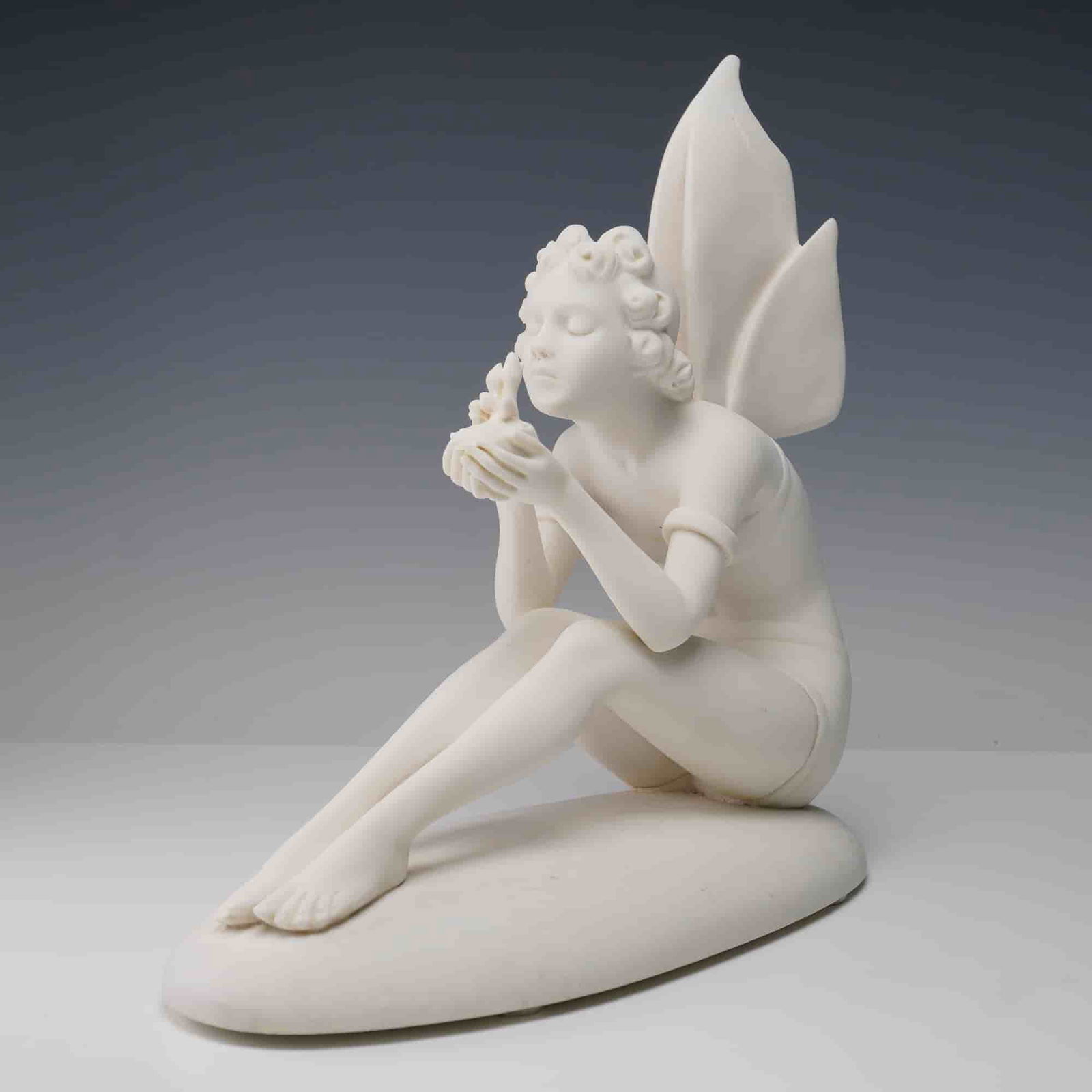 Santini-Style Sprite Figurine with Baby Birds: Santini-style figurine depicting a seated sprite or fairy with butterfly wings, tenderly holding baby birds in her hands. Crafted of molded marble dust and resin and mounted on an oval base with