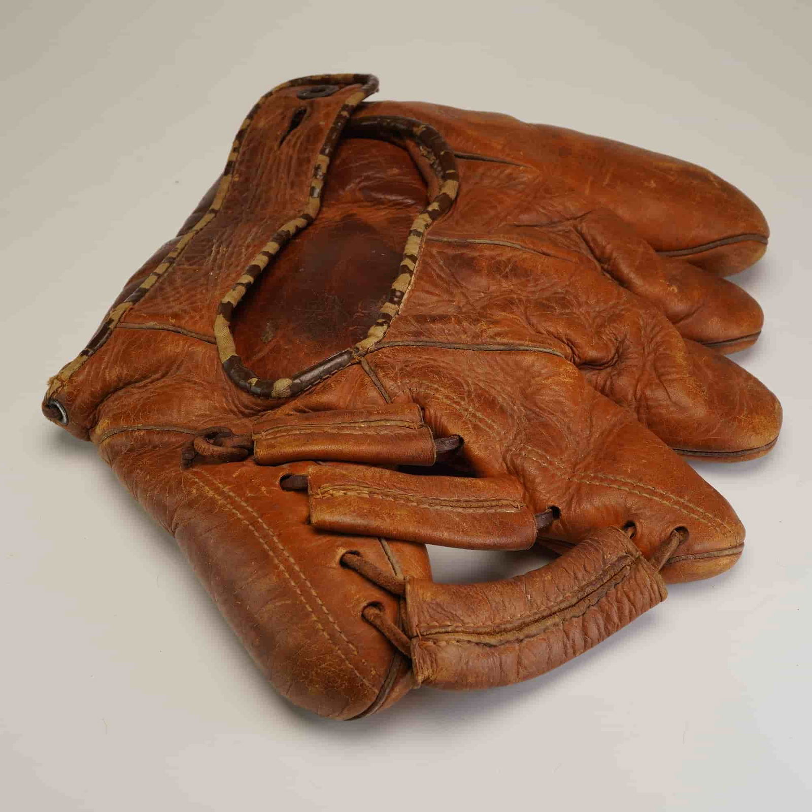 MacGregor Goldsmith Split-Finger Leather Baseball Glove, Unauthenticated: This is a vintage MacGregor Goldsmith split-finger leather baseball glove, a classic design prevalent during the 1930s and 1940s. The glove is constructed from heavy-duty tanned leather and features