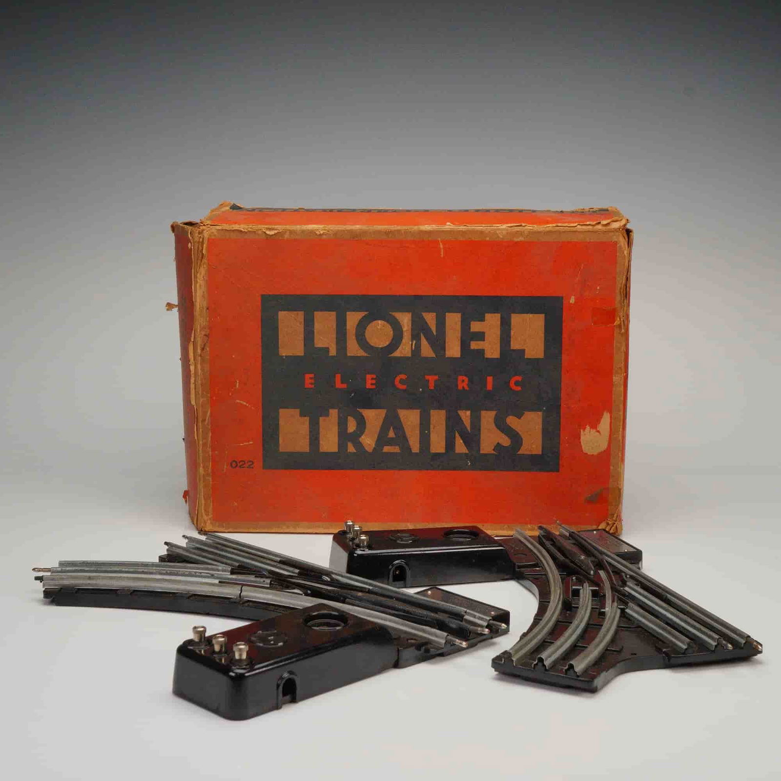 Pair of Lionel No. 022 O Gauge Remote Control Switches with Original Box: A collection of three items related to Lionel "O" Gauge model electric train accessories, comprising two remote control track switches and one original packaging box. The switches are identified as th