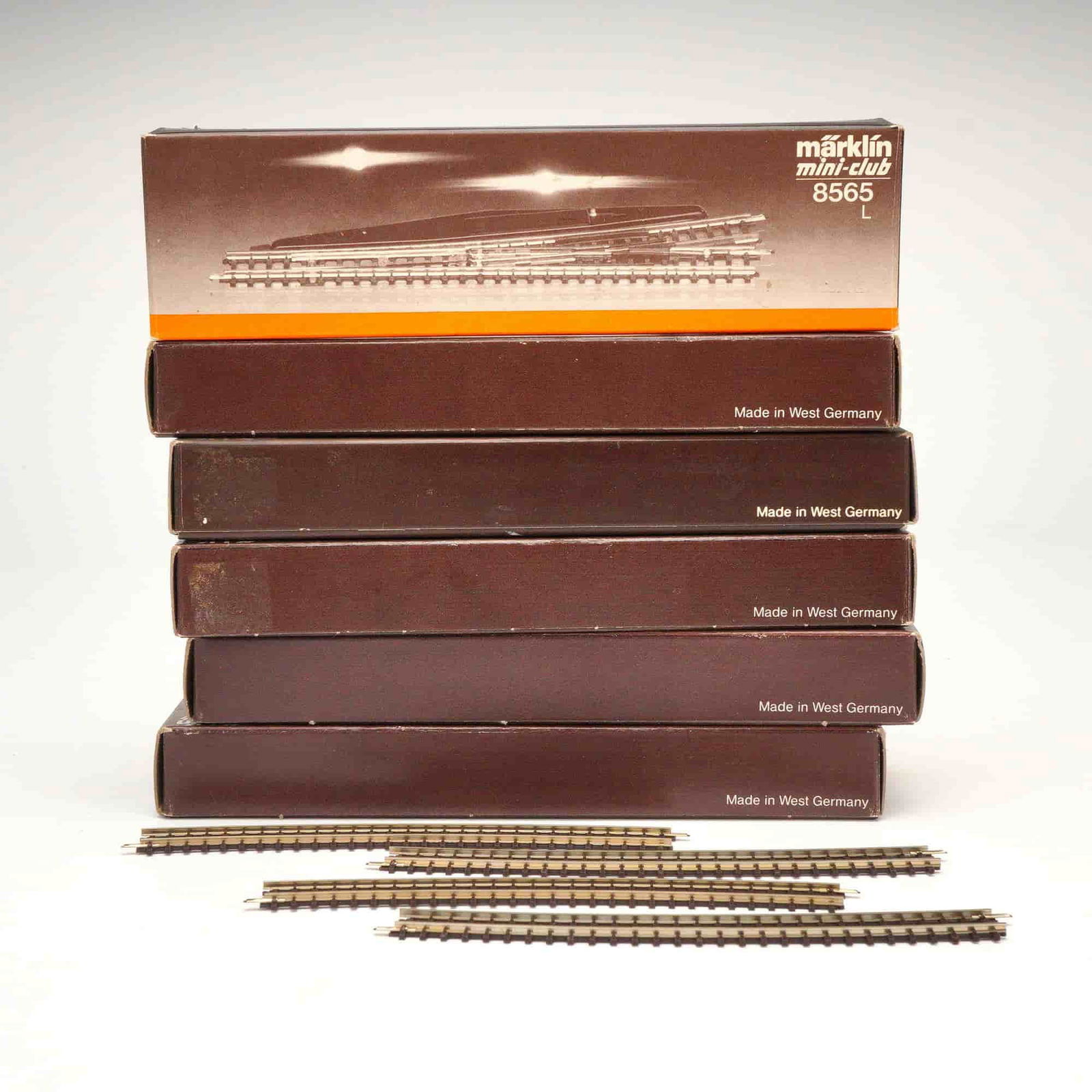 Group of Marklin Mini-Club Z Gauge Track Sections and Train Components: A group of Marklin mini-club Z Gauge model train track sections and their associated packaging. The lot includes five brown cardboard boxes, each marked "Made in West Germany." The top box is