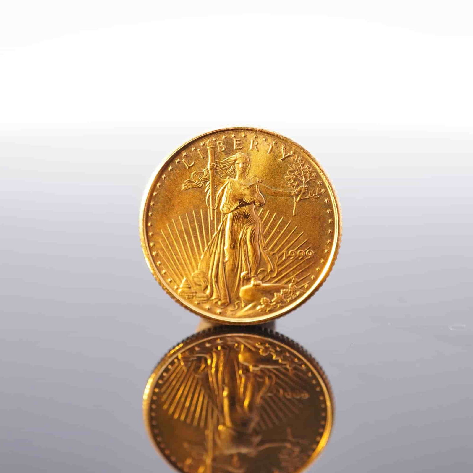 1999 1/10 Fine Gold $5 American Gold Eagle Coin: Minted by the Philadelphia Mint. The obverse side depicts an effigy of Liberty with the date to the right. The reverse side depicts an eagle in flight above a nest of birds with the country name at th