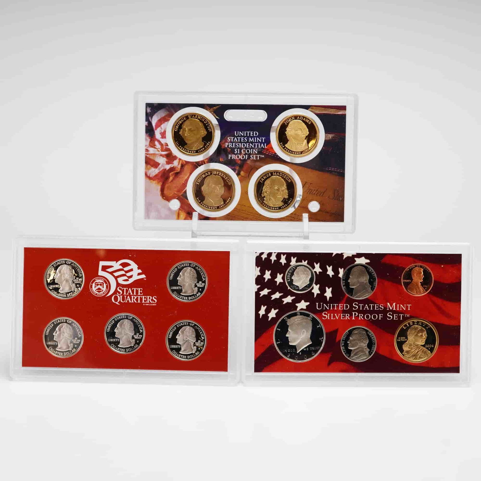 US 2004 Silver Proof Set and 2007 Presidential $1 Coin Proof Set: A collection of two United States Mint proof sets in original government packaging. The 2004 Silver Proof Set contains ten coins: five 90% silver State Quarters (Michigan, Florida, Texas, Iowa, and Wi