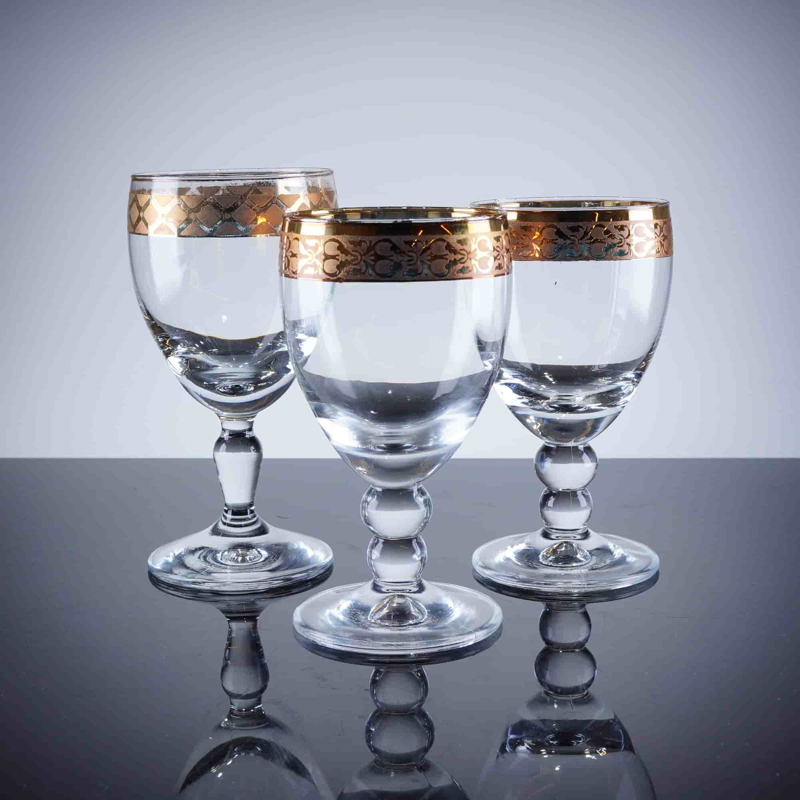 3pc Gold Rim Crystal Wine Glasses: A trio of stemmed drinking glasses, featuring heavy gold-gilt decoration applied to the rim and upper bowl section. The decoration consists of a solid gold band at the rim, which two glasses display