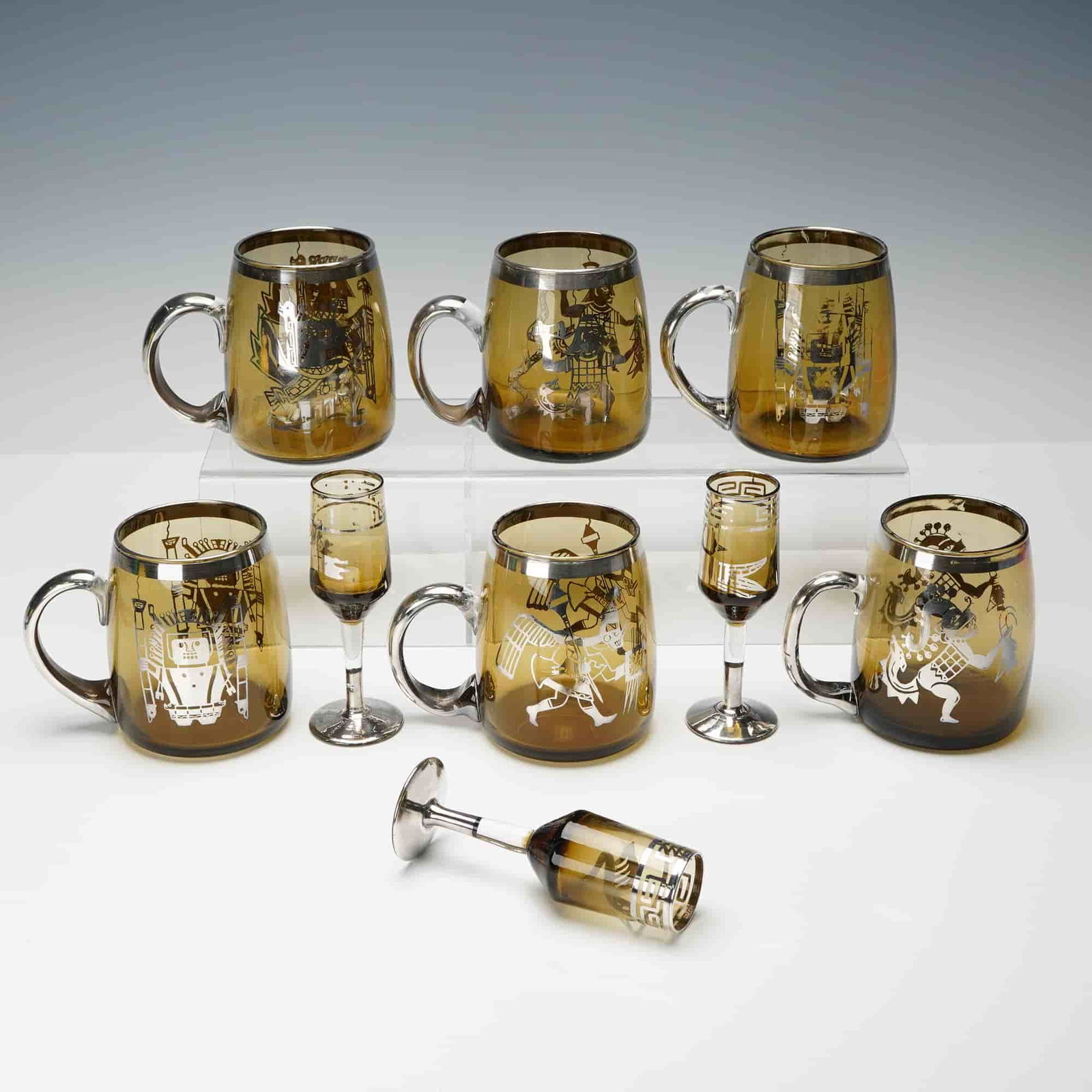 9pc Silver Overlay Figural Motif Amber Glass Mugs and Cordials Set: Beverage set consisting of six handled amber glass mugs and three matching cordials, each decorated with silver overlay and stylized Mesoamerican figural scenes. The mugs feature wide rounded forms