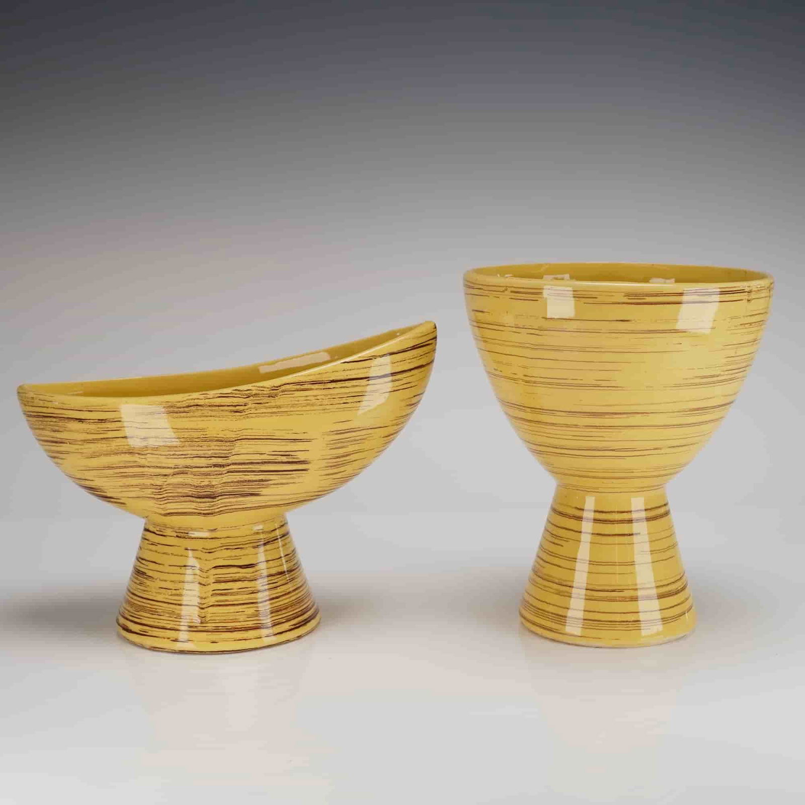 2pc McCoy Pottery Yellow and Brown Striped Footed Vessels: Two vintage McCoy Pottery footed ceramic vessels, consistent with mid-century modern design. The 2pc set includes a tall, tapered vase-like form and a lower, elongated, asymmetrical boat-shaped bowl.