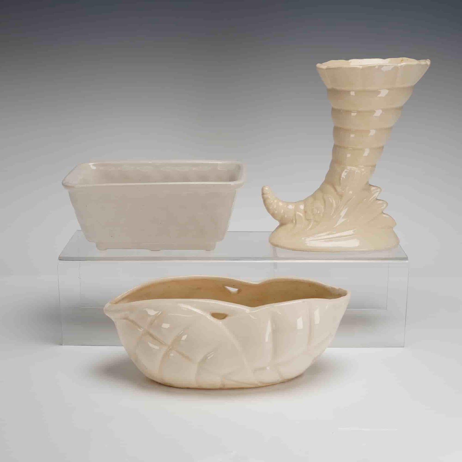 3 McCoy Pottery Planters - Cornucopia, Rectangle & Oval: A trio of glazed ceramic planters attributed to McCoy Pottery, characteristic of mid-century American art pottery. The collection includes three distinct forms, all finished in a uniform pale ivory