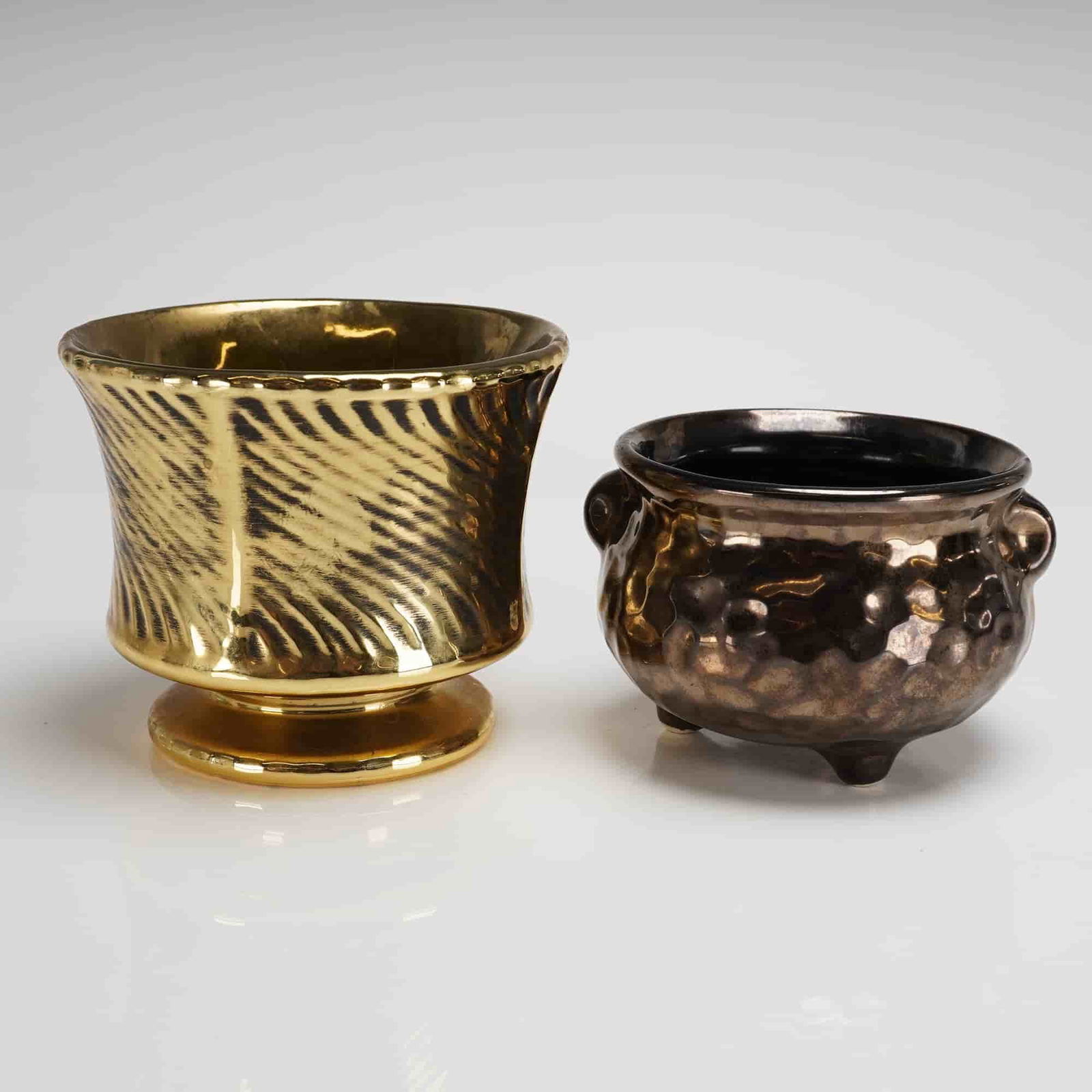 Two McCoy Pottery Floraline Luster Planters: Two ceramic decorative planters attributed to McCoy Pottery, likely from the Floraline line, exhibiting metallic luster glazes and a mid-century aesthetic. The collection consists of two distinct