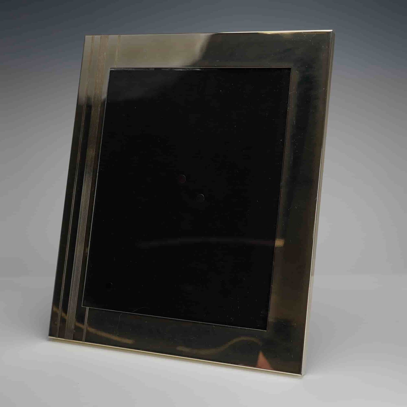 Kate Spade Lenox Art Deco Style Silver Toned Picture Frame: A contemporary picture frame produced by Kate Spade New York for Lenox. The silver-toned metal frame exhibits Art Deco styling, characterized by a wide, polished border accented by a section of finely