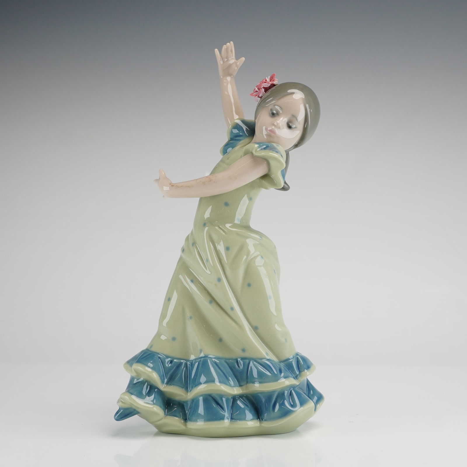 Lladro Lolita Flamenco Dancer Porcelain Figurine, Model 5308: A fine glazed porcelain figurine by Lladro titled Lolita, model number 5308, depicting a young girl in a traditional Spanish flamenco dance pose. The figure is dressed in a pale green traje de flamenc